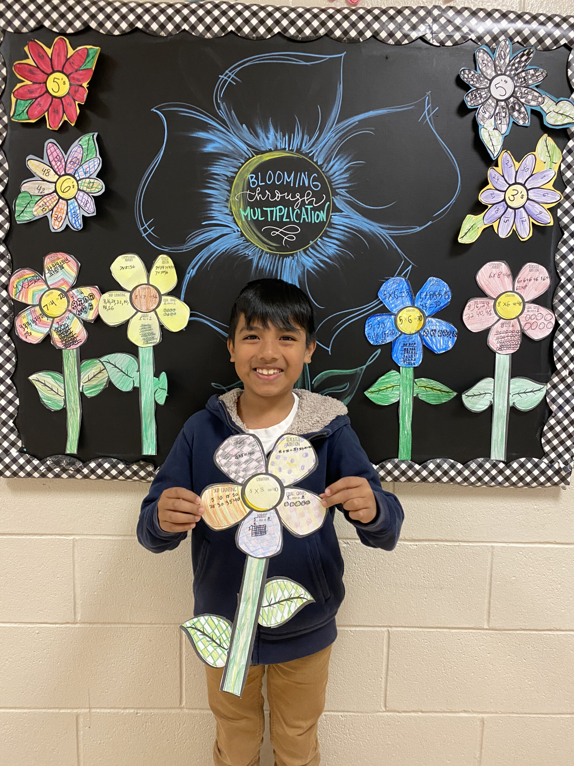 Students in Claire Urizzo’s class at Hampton Bays Elementary School, including Cristofer Huerta Potrero, practiced and memorized multiplication problems through a creative, spring-themed project. Each student received a paper flower and a multiplication problem. They were then challenged to make an array, skip count, and show repeated addition and equal groups related to the problem on each petal of the flower. COURTESY HAMPTON BAYS SCHOOL DISTRICT