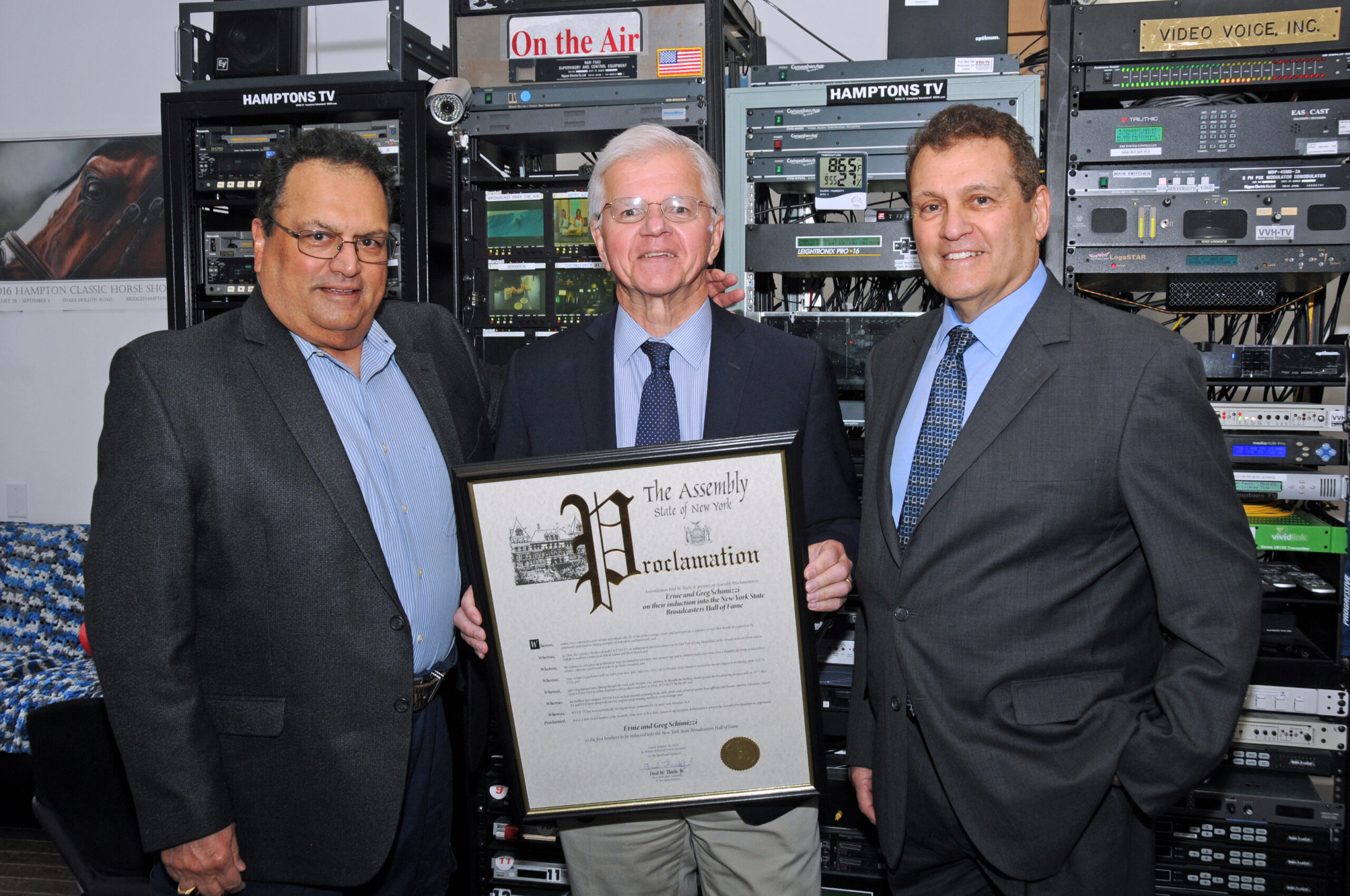 NYS Assembly Member Fred Thiele Jr., center, presented a proclamation to WVVH-TV founders and co-owners Ernie and Greg Schimizzi on Friday, in honor of their induction into the NYS Broadcasters Hall of Fame. They are the first brothers ever inducted.              RICHARD LEWIN
