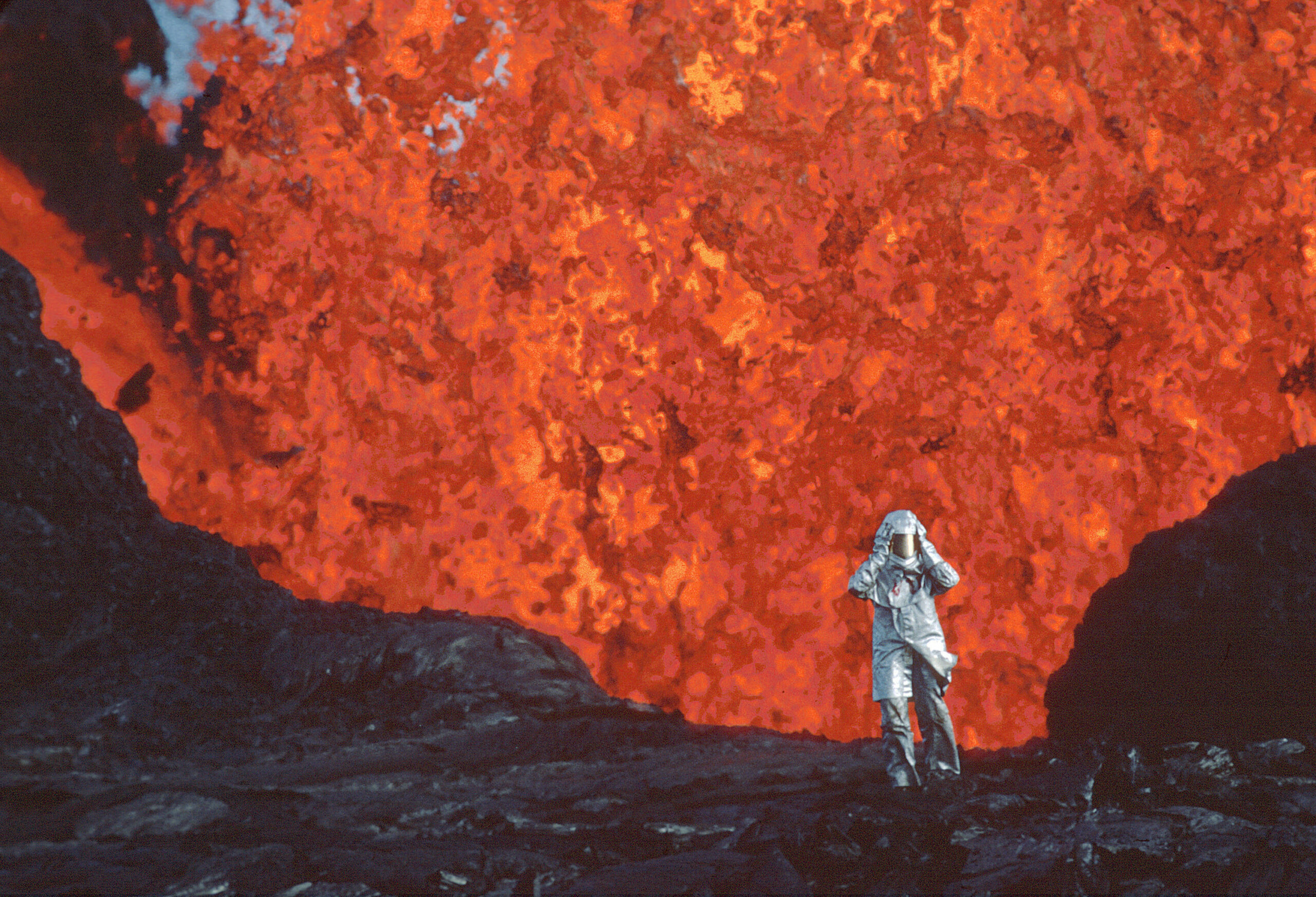Katia Krafft wearing aluminized suit standing near lava burst at Krafla Volcano, Iceland. IMAGE 'EST