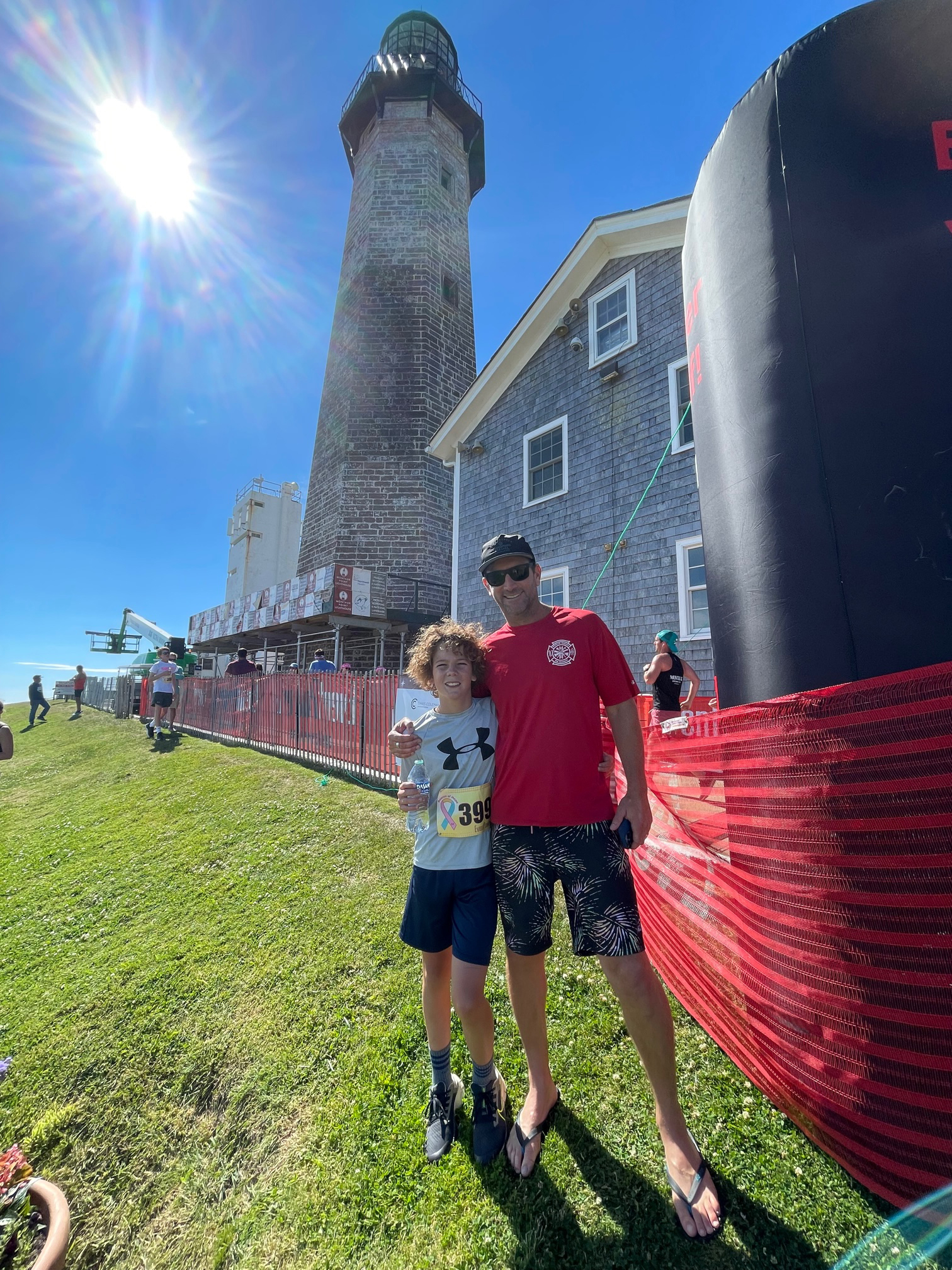 Liam Wilson, 12, and his father George near the finish line of Saturday’s race at the Montauk Point Lighthouse.       GAVIN MENU