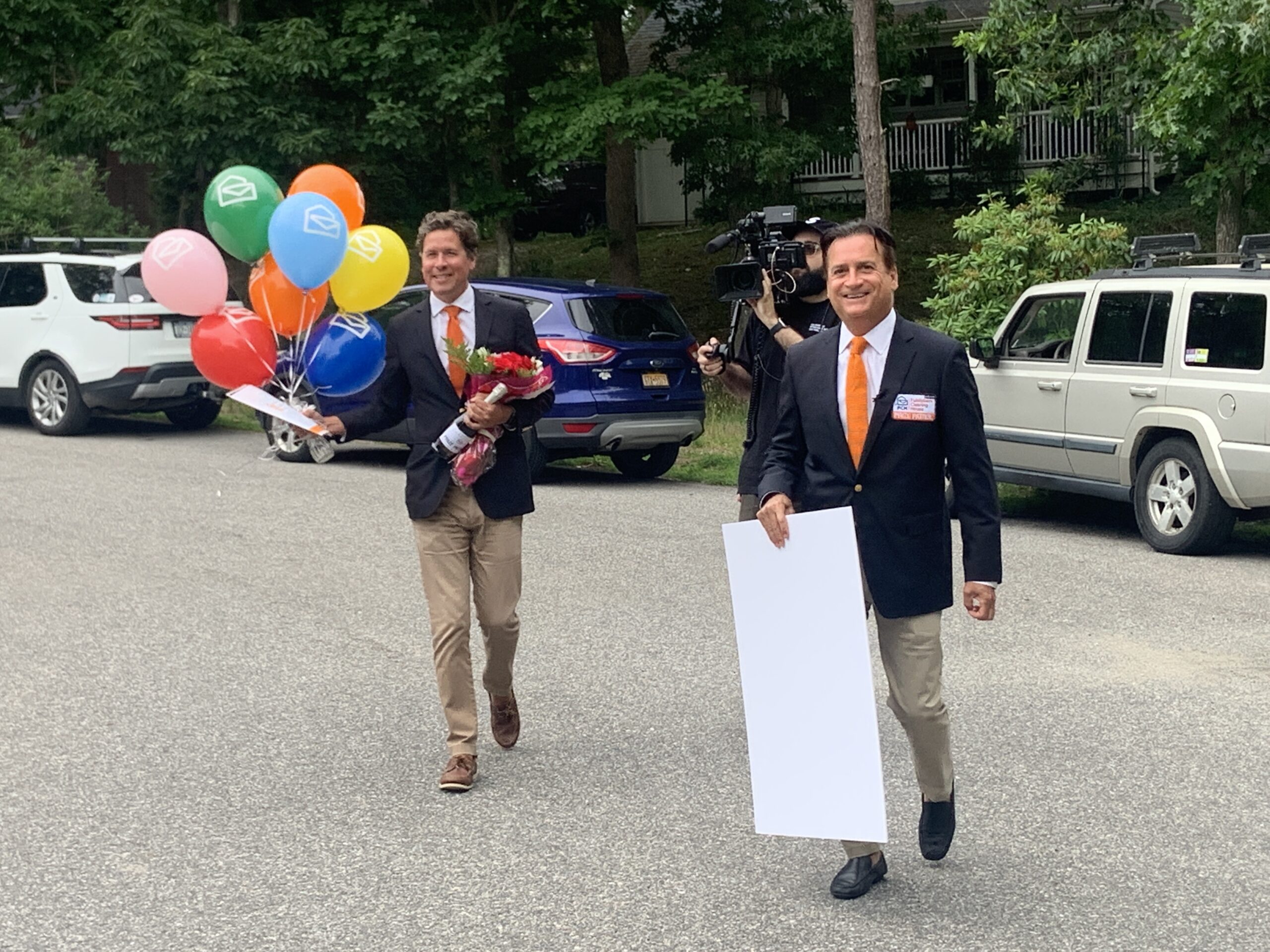 Howie Guja, left, and Todd Sloane, with cameraman George Mantzoutsos trailing close behind, make their way to Lynn Bromberg's Noyac home. STEPHEN J. KOTZ