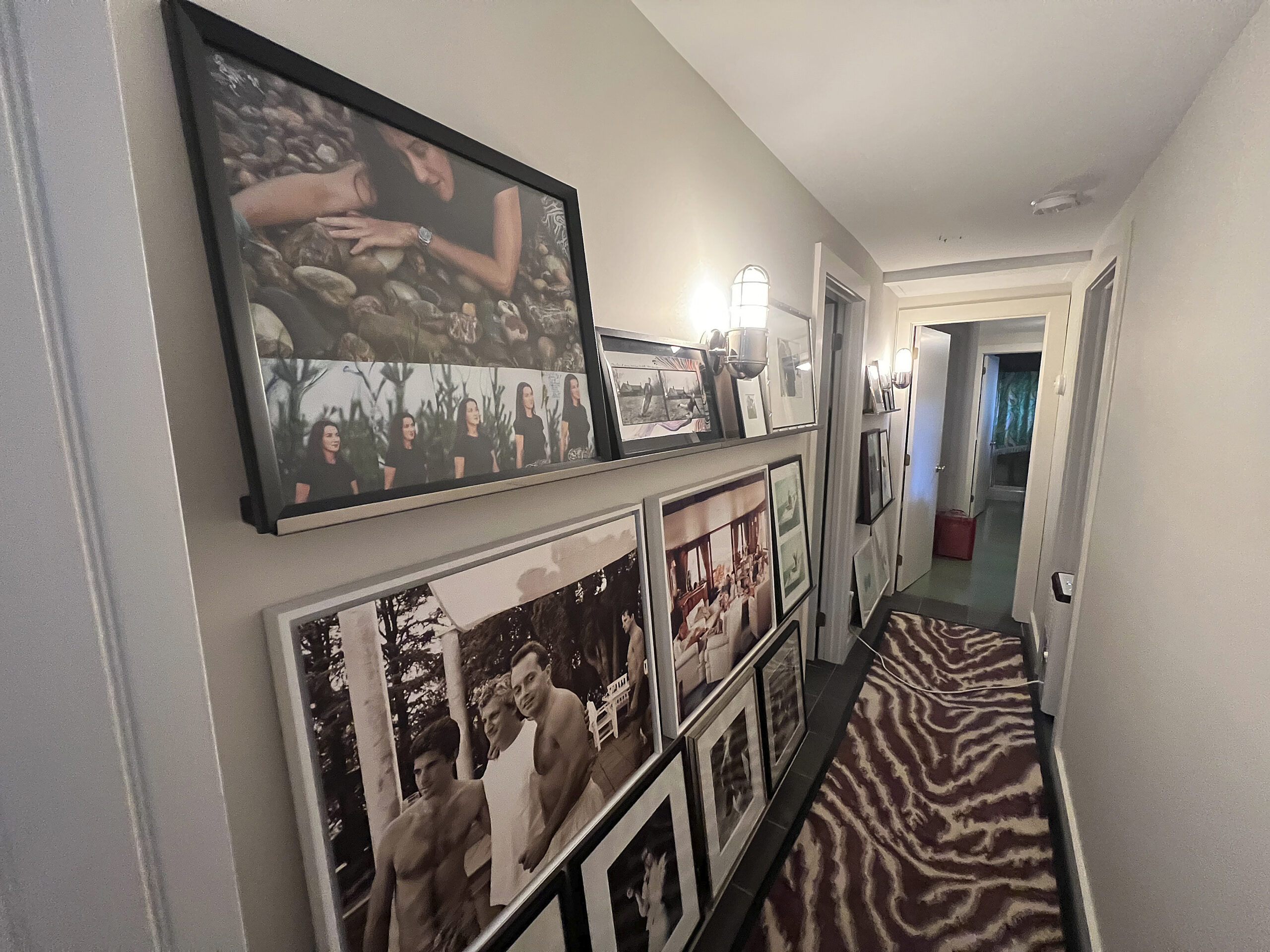Photographs by Slim Aarons, Kelly Klein and Peter Beard adorn the hallway walls.   DANA SHAW