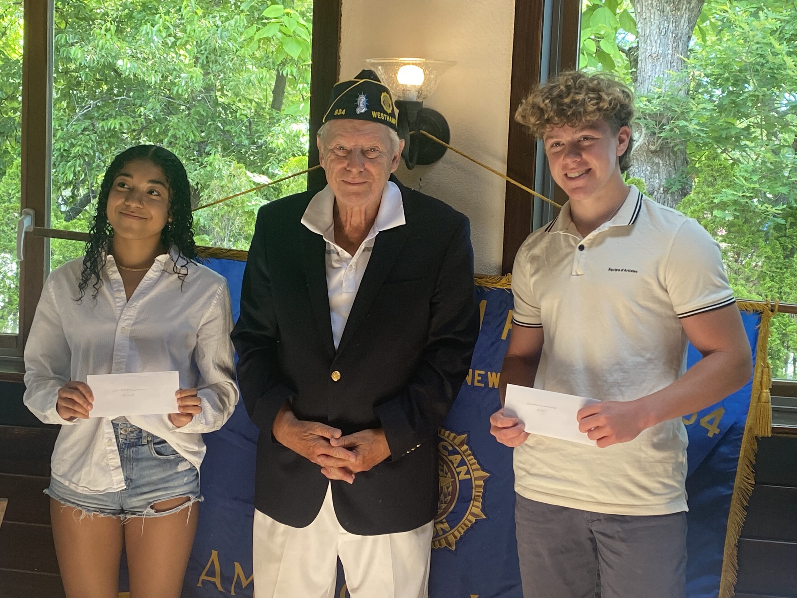 Olivia Reid, left, and Aiden Berdinka were presented with scholarship checks from Tom Hadlock, commander of the American Legion Post 834 Westhampton, at a meeting on  June 18.