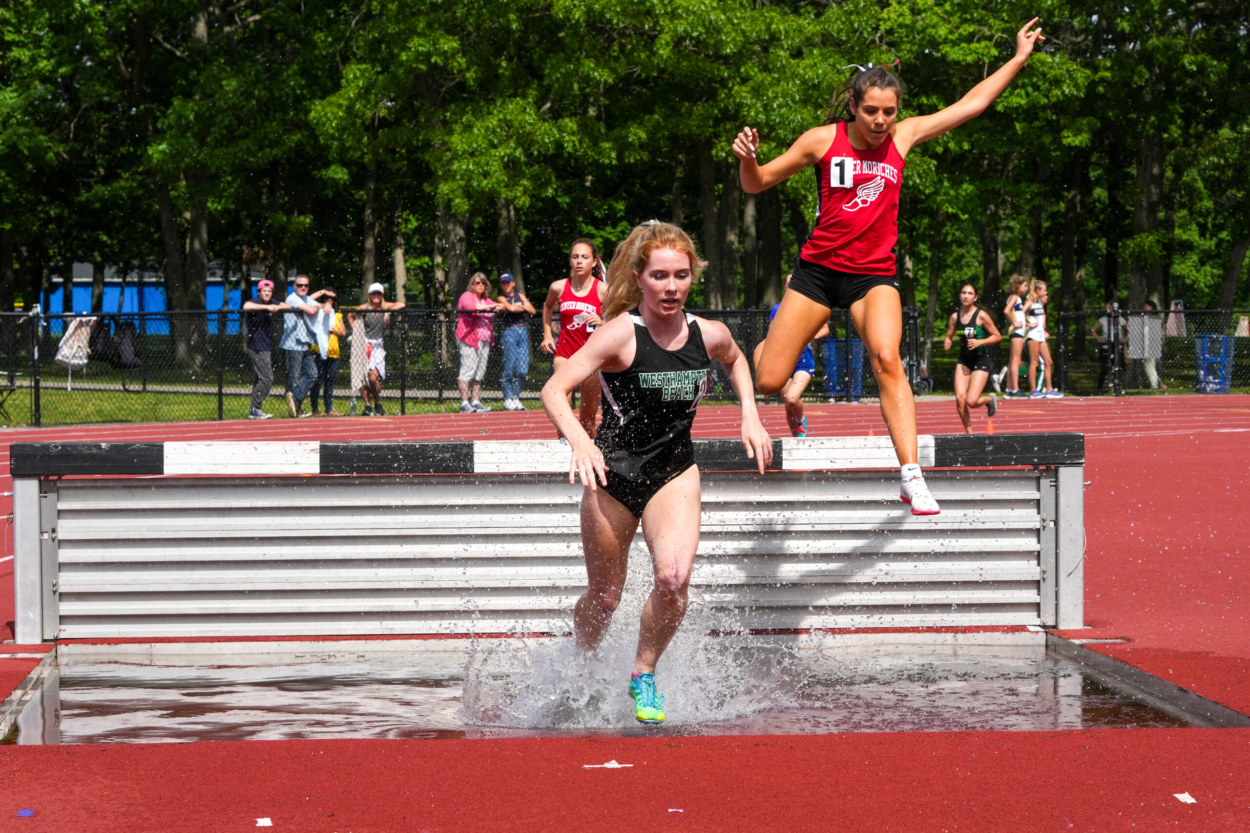 Senior Keira Falvey jumps a hurdle in the 1,000-meter steeplechase at the state qualifiers. RON ESPOSITO
