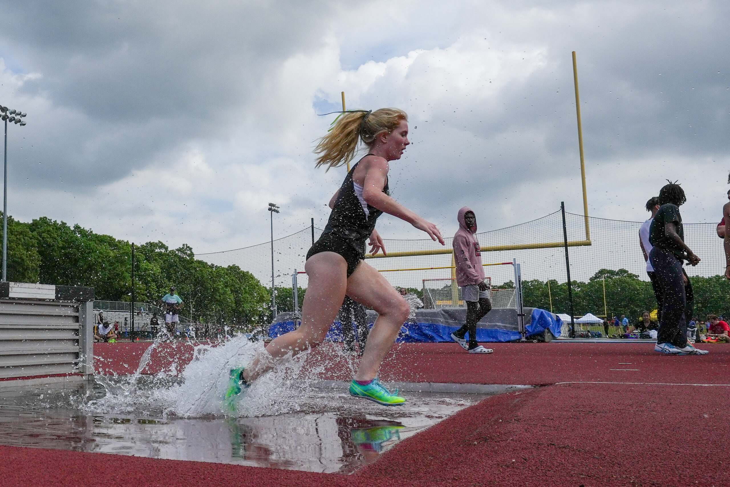 Senior Keira Falvey jumps the water in the 1,000-meter steeplechase at the state qualifiers. RON ESPOSITO