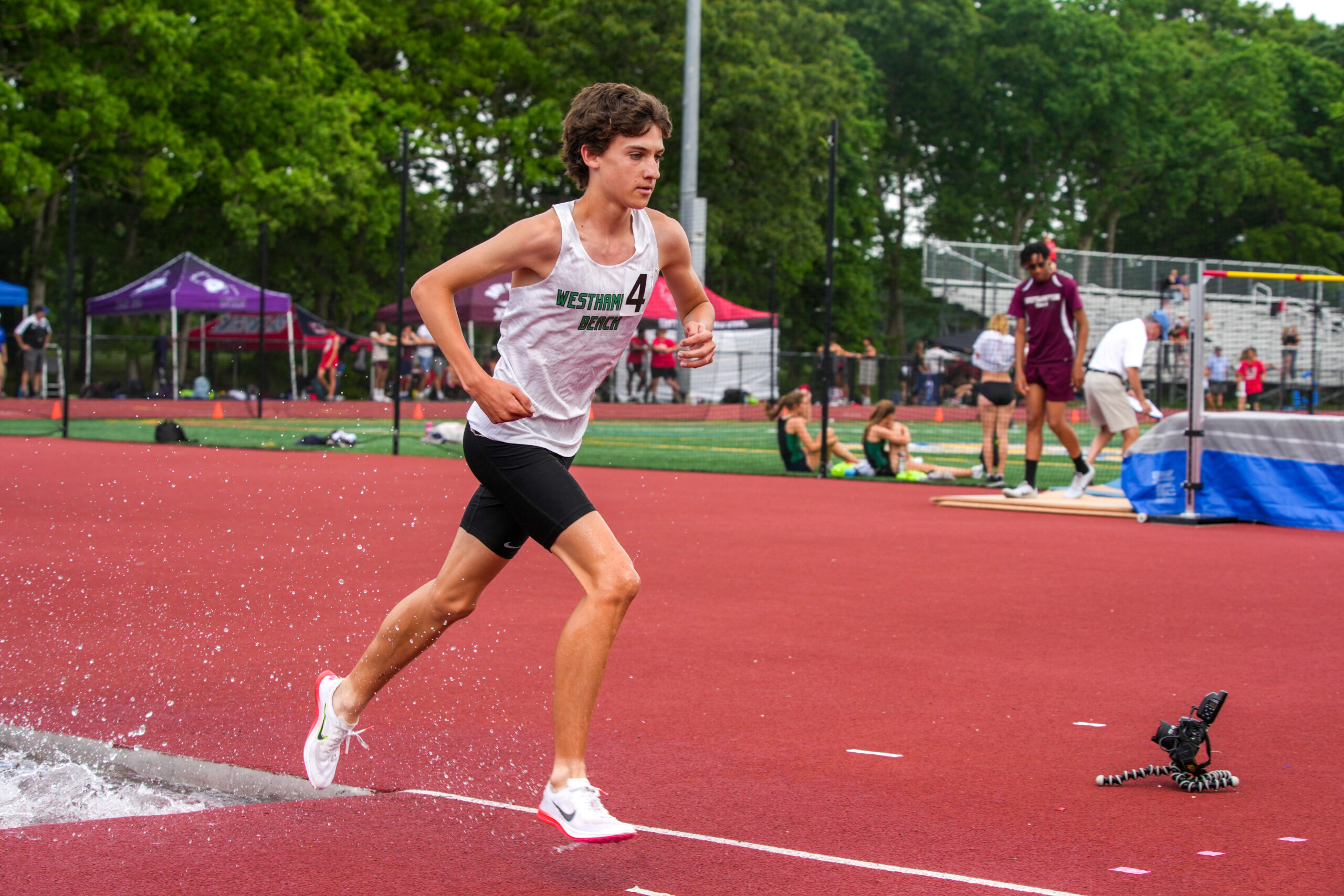 Sophomore Trevor Hayes exits a water jump in the 3,000-meter steeplechase at the state qualifiers. RON ESPOSITO