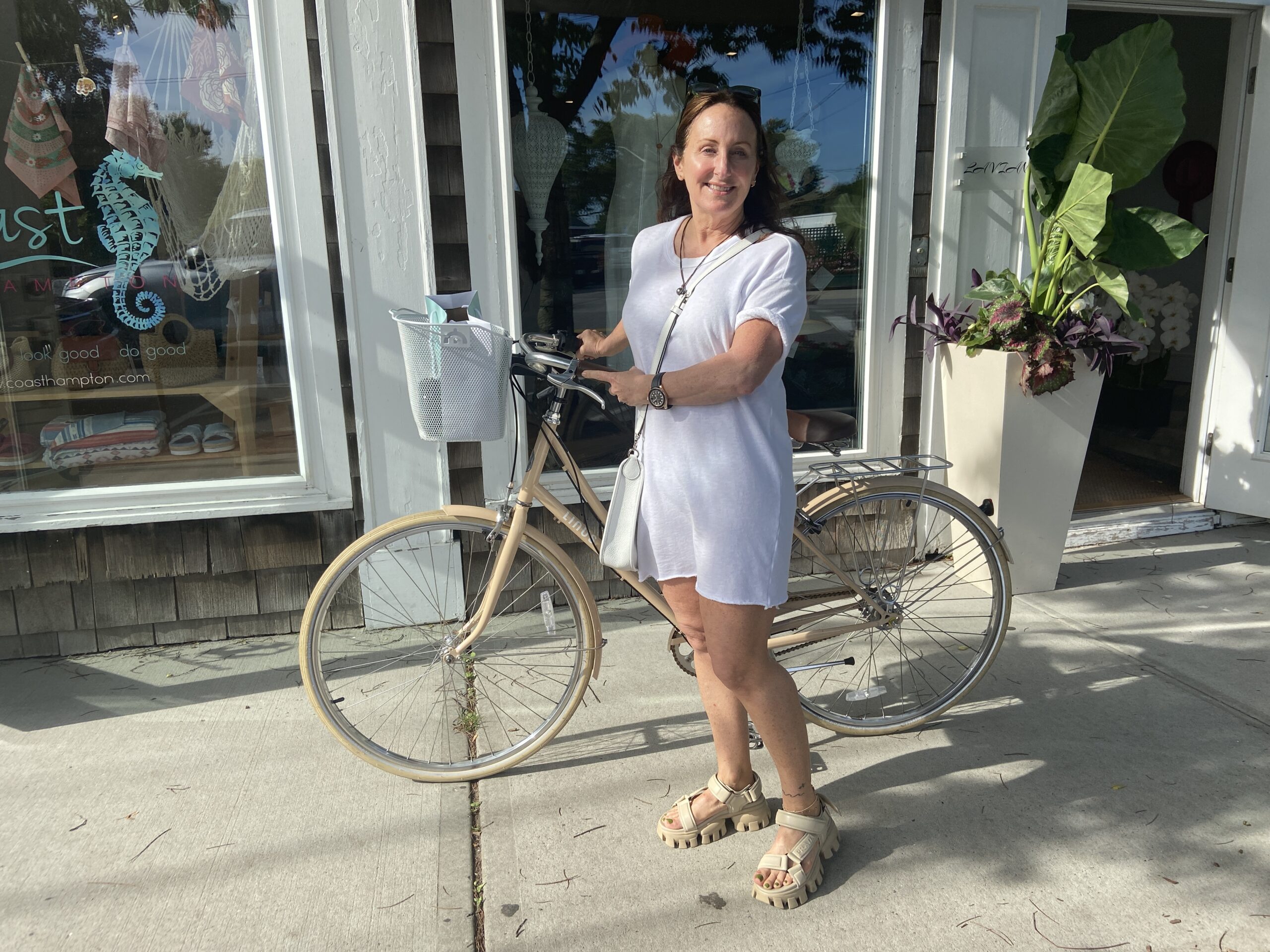 BY JULIA HEMING Laurie Kamisky of Southampton with her bike in a coastal grandmother white tee shirt dress.