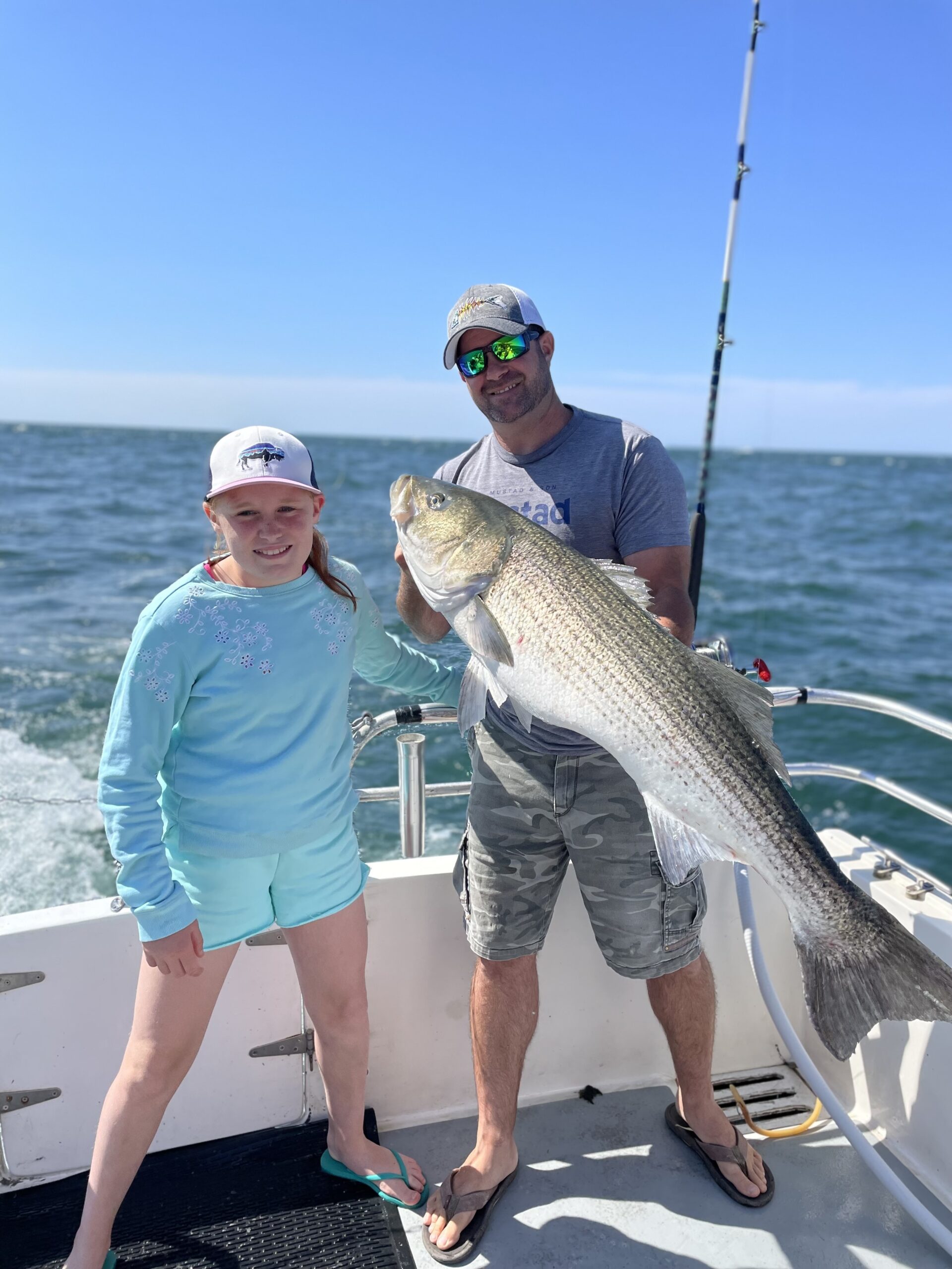 Eloise Hawtin gets a hand from Capt. Dan Giunta showing off a big striped bass she caught while fishing aboard Giunta's charter boat Double D off Montauk recently.