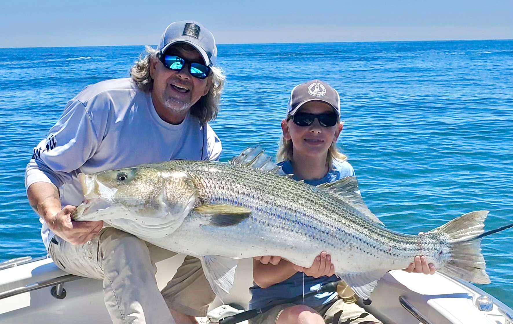 Steve and Devin Petras heft a striped bass that bottomed out a 60-pound scale, from the waters off Shinnecock Inlet last week.