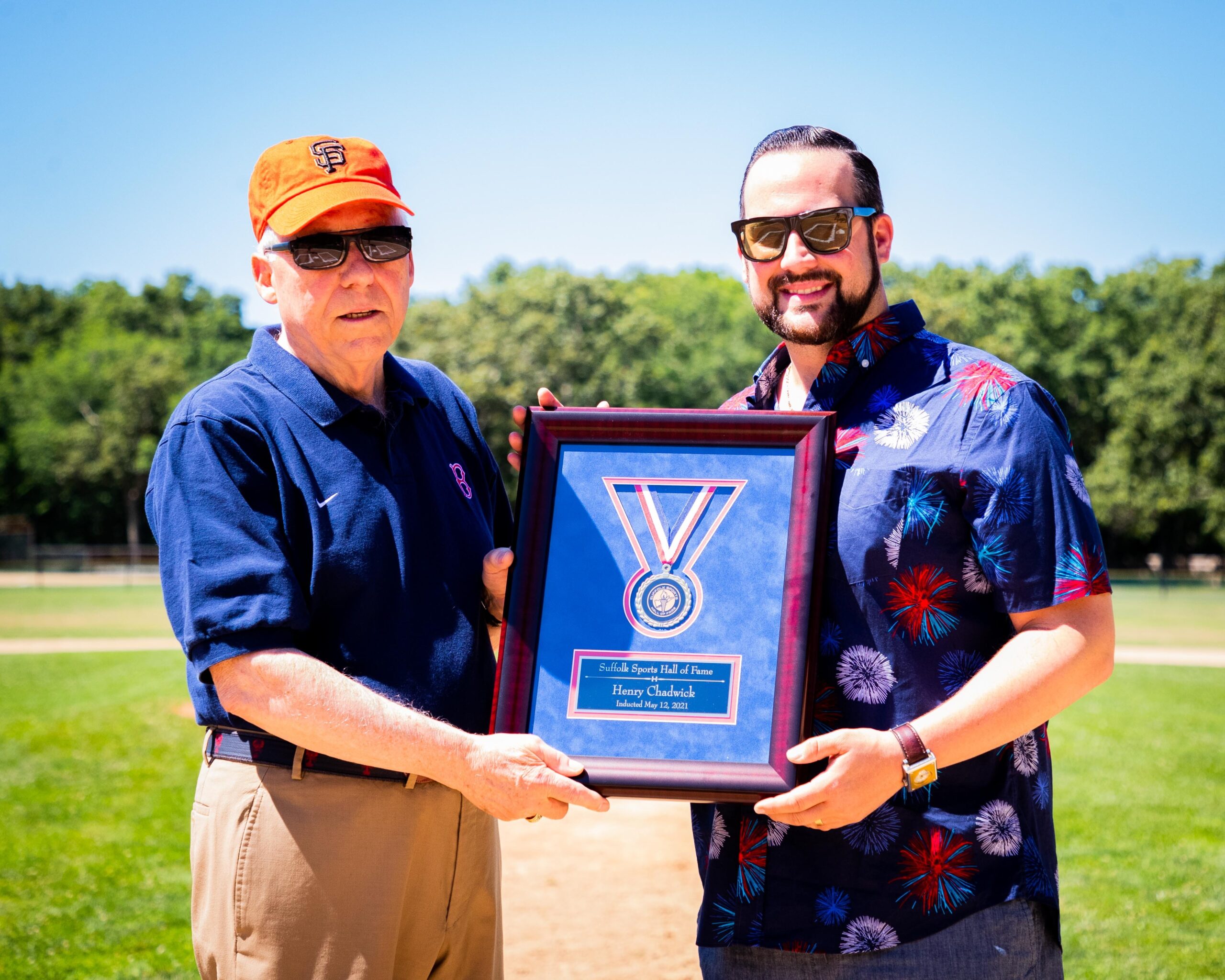 Jack Youngs, left, is presented Henry Chadwick's medal from Suffolk Sports Hall of Fame President Chris Vaccaro at Mashashimuet Park in Sag Harbor on Monday.   DEMETRIUS KAZANAS