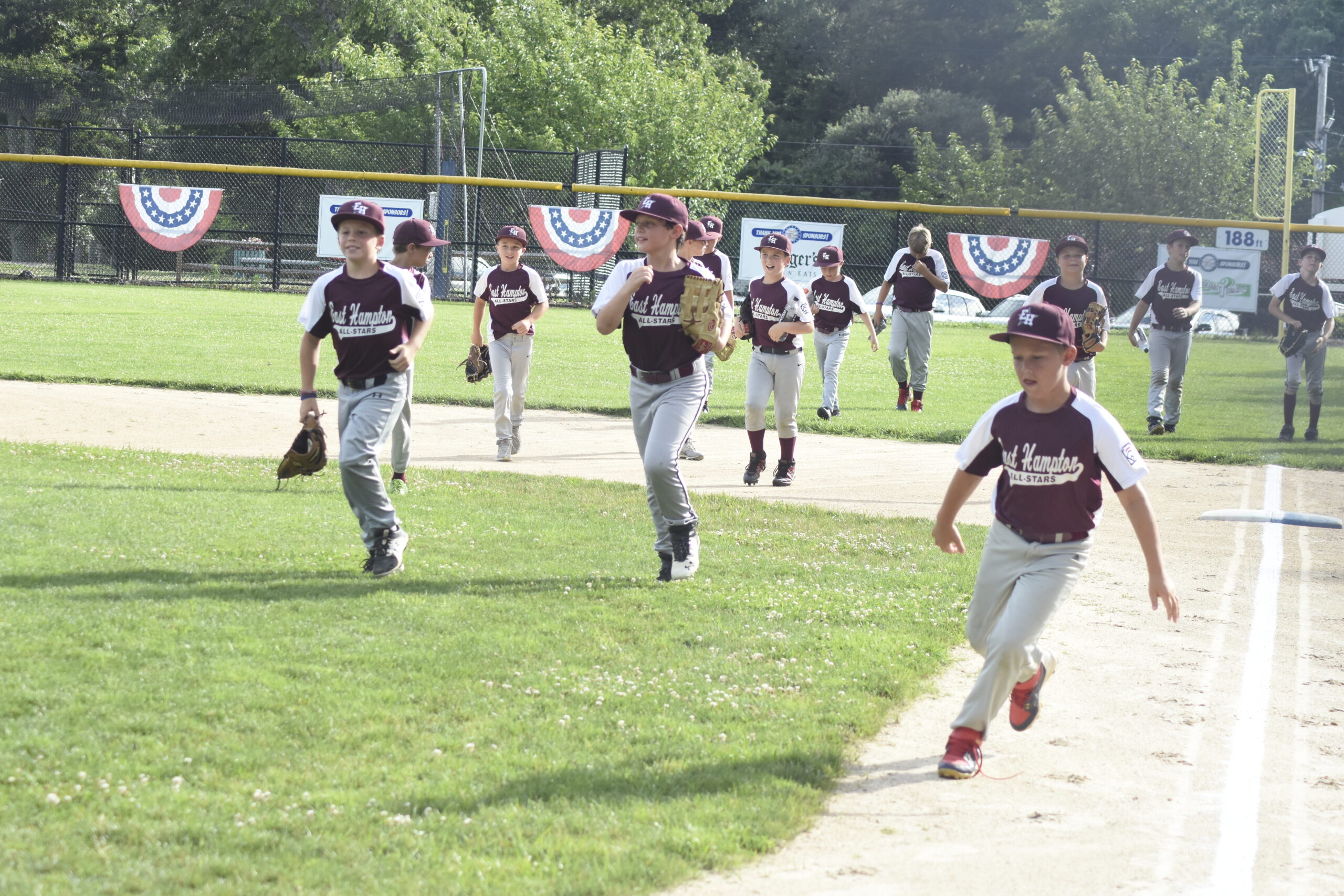 The East Hampton Minors All-Stars race to their dugout just prior to their game on July 6.   DREW BUDD