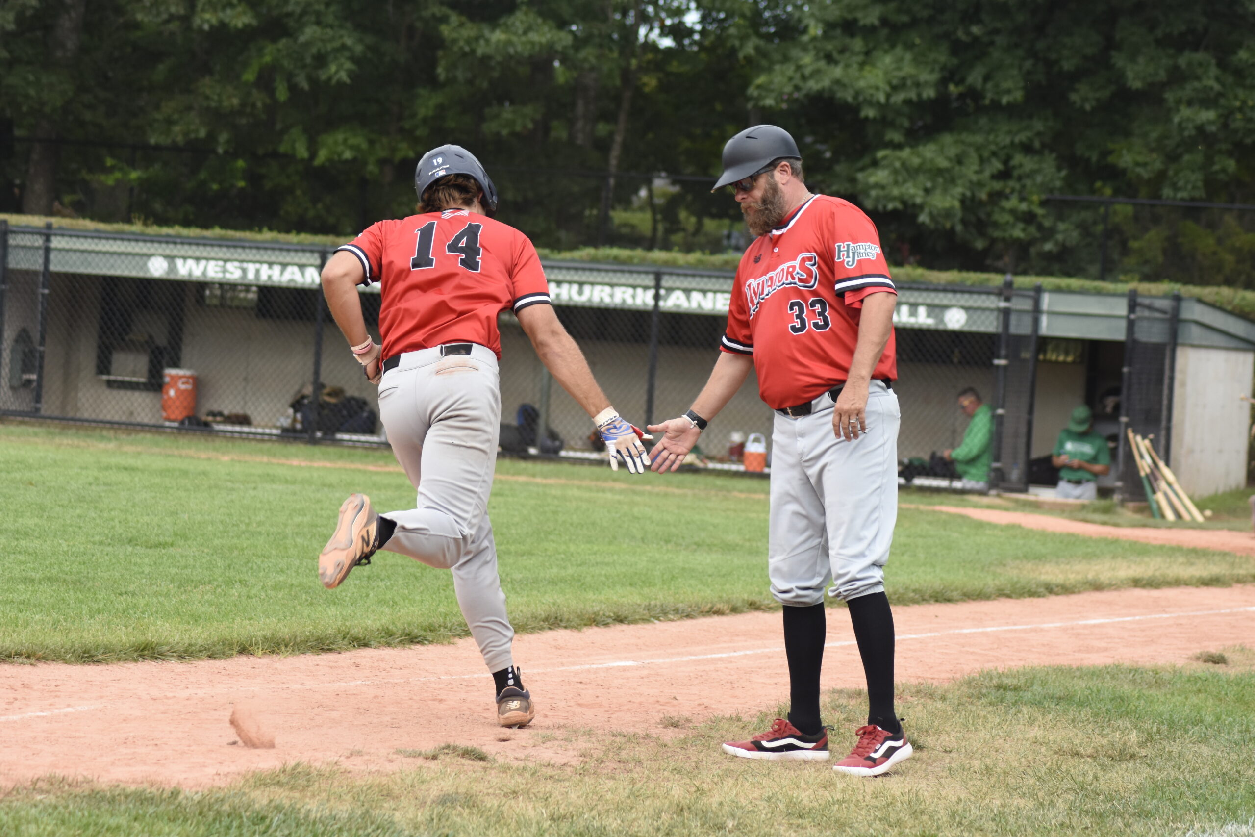 Jack Halloran is congratulated by manager Jason Jacome as he rounds third base.    DREW BUDD