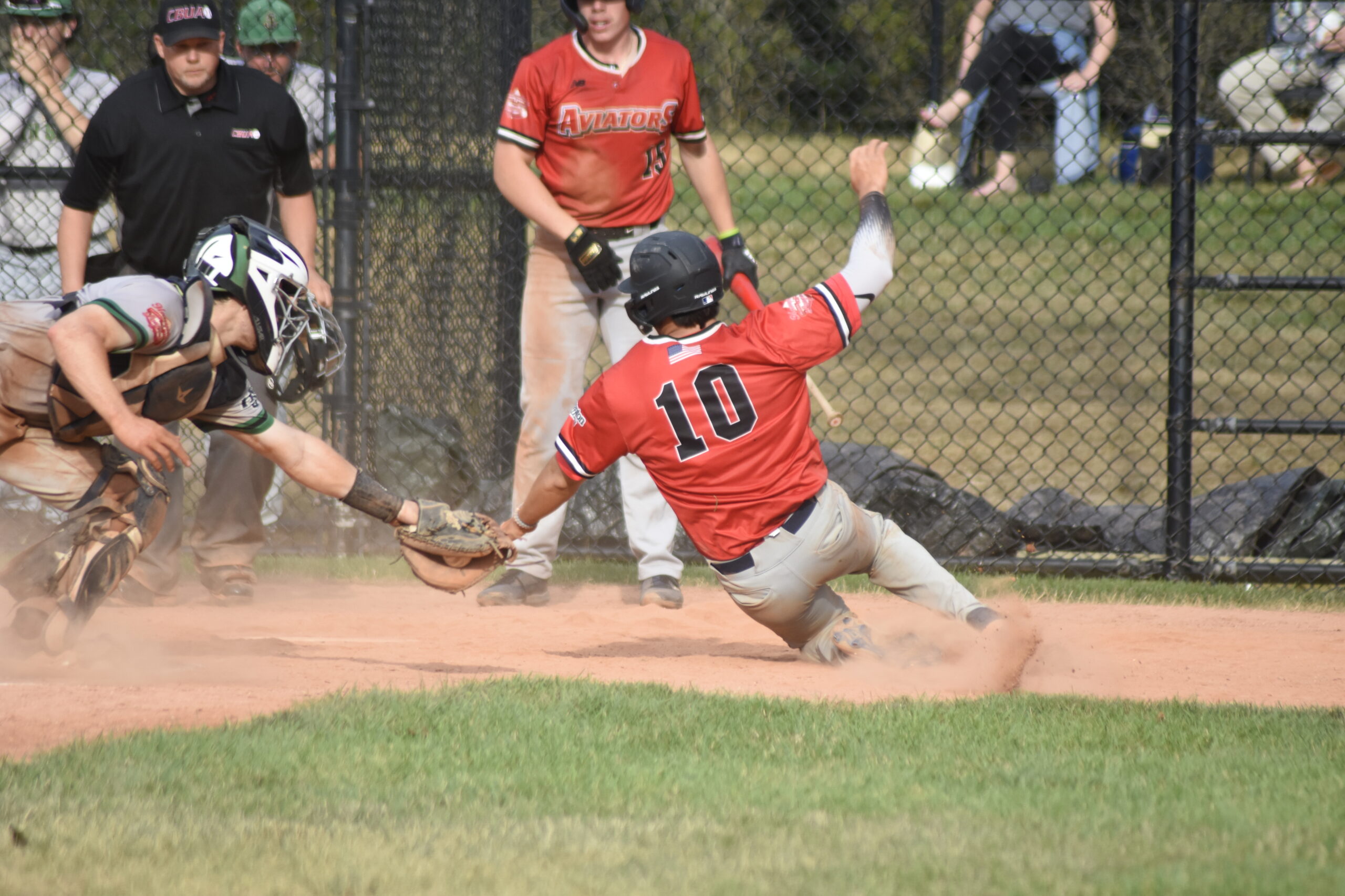 Mason Wolf (Monmouth) avoids being tagged and slides safely at home.    DREW BUDD