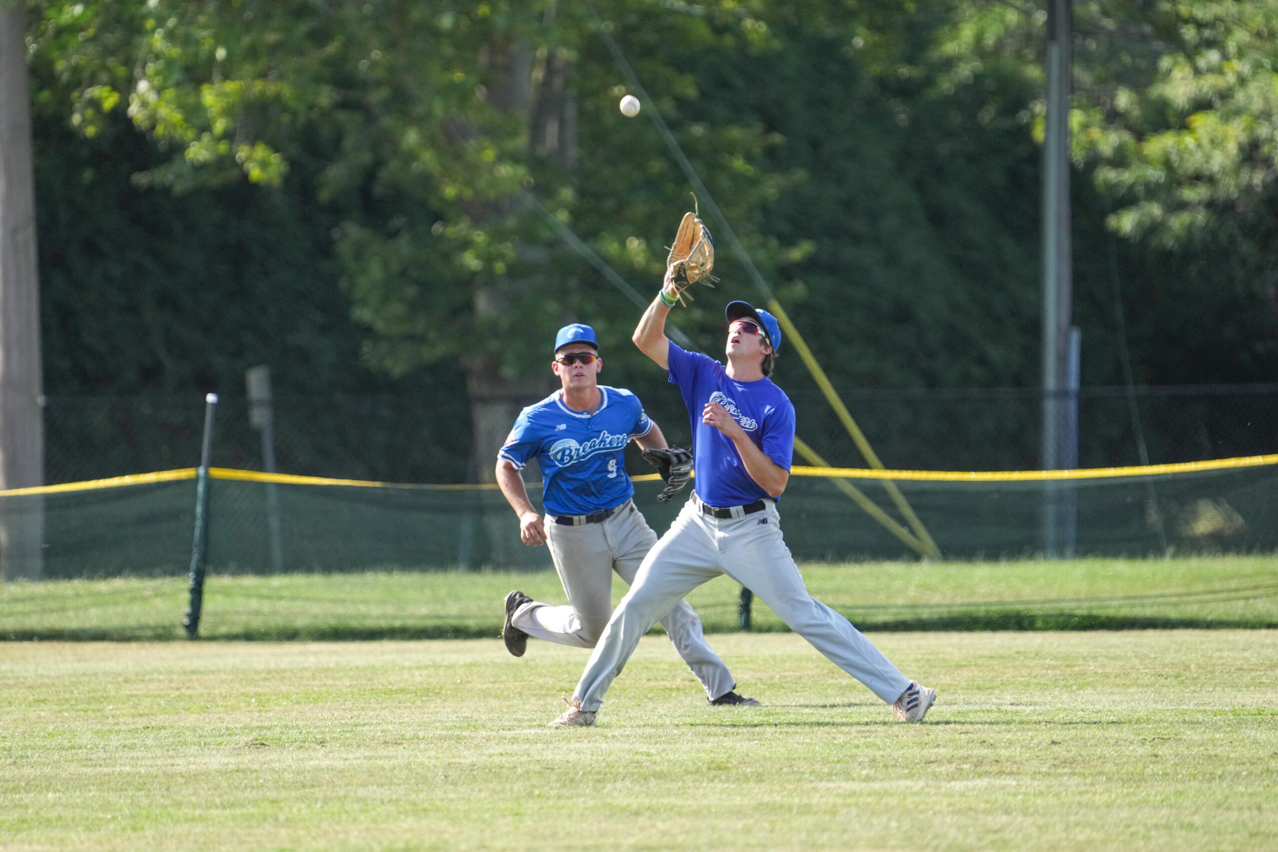 Breakers centerfielder Beau Root (Middlebury) settles underneath a fly ball with Andrew Smith (Queens) backing him up.    RON ESPOSITO