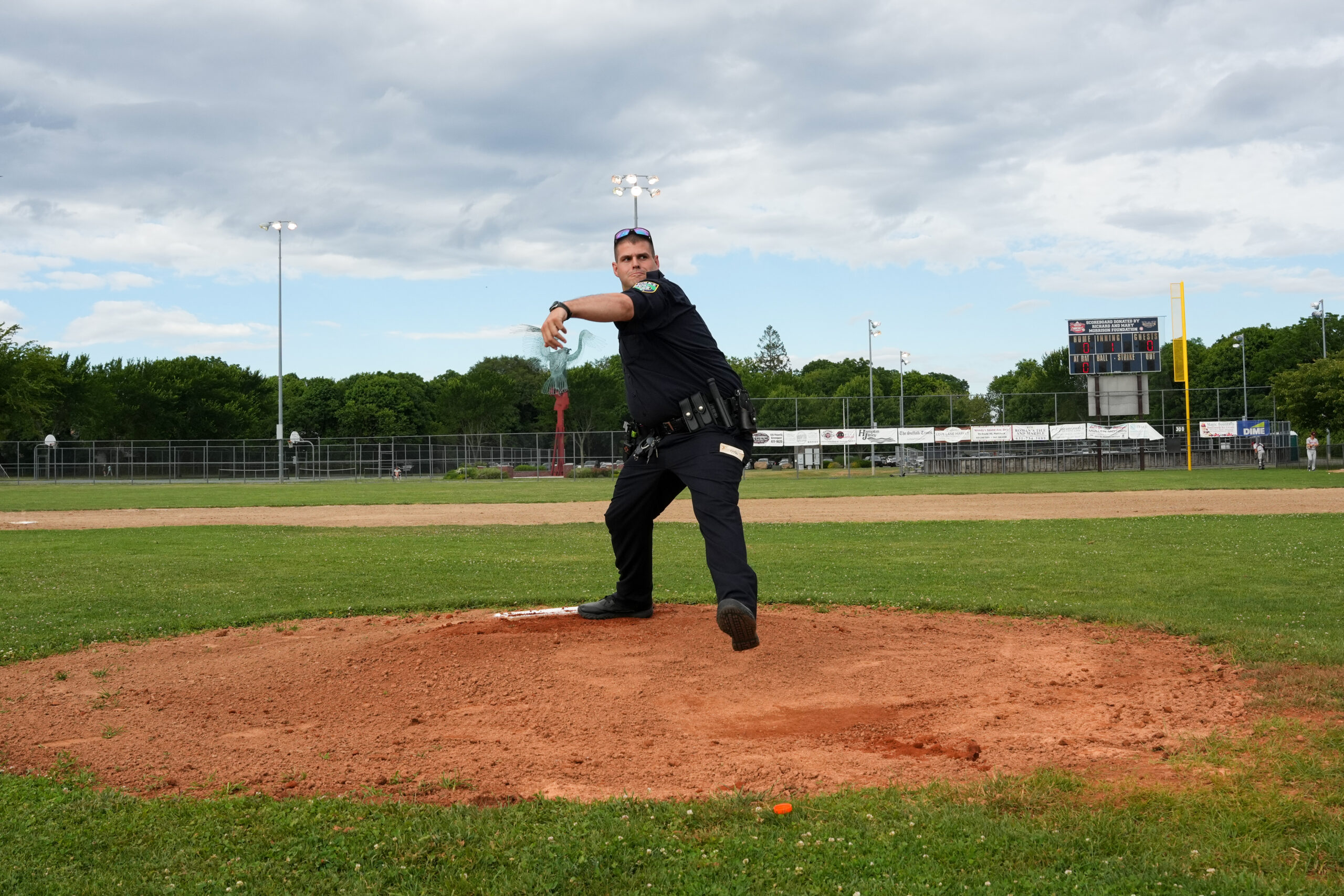 Former Riverhead Tomcat and current police officer Jimmy Luppens threw out the first pitch in uniform.   RON ESPOSITO
