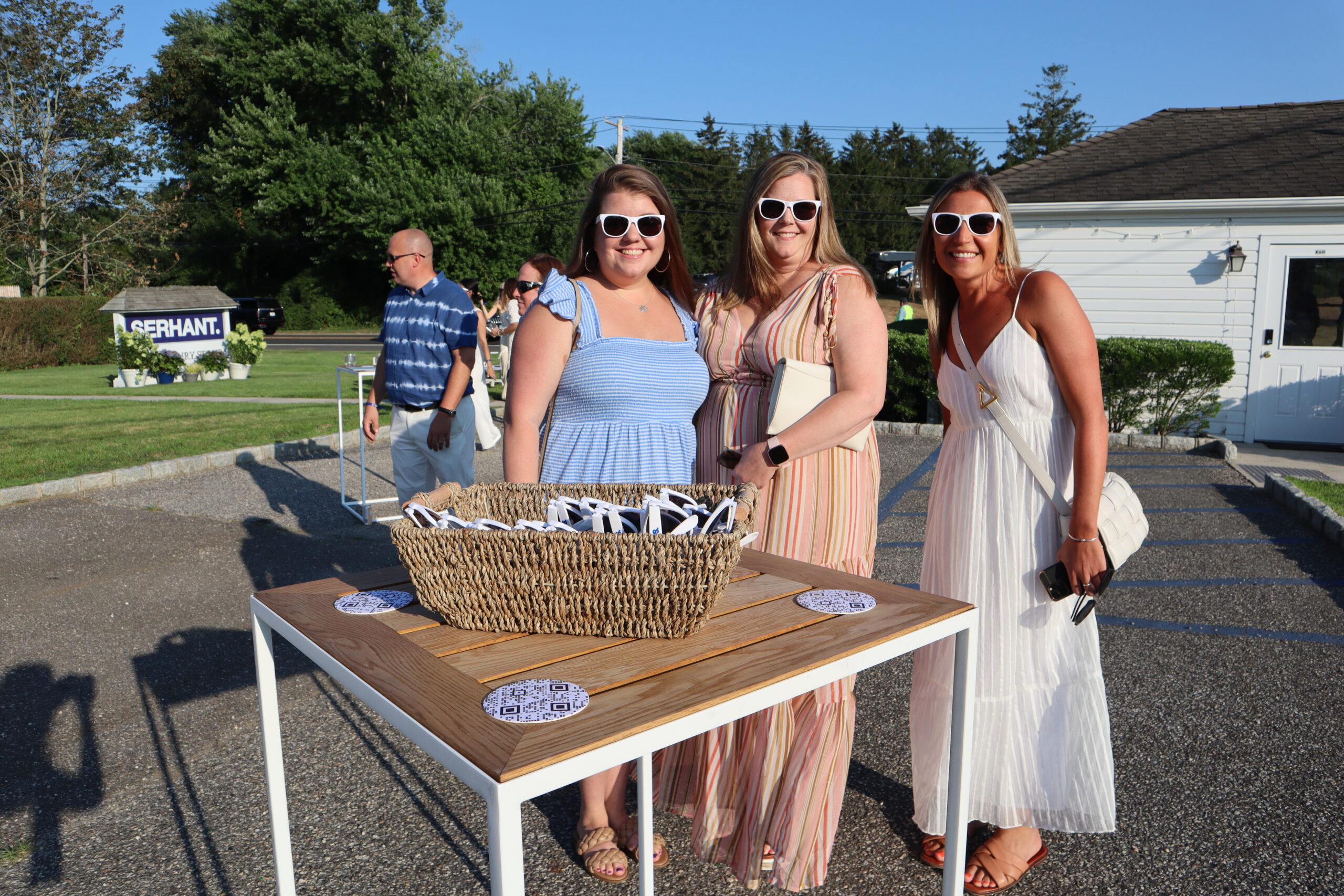 Kristina Paces, a broker at Serhant, right, Donna Downs, Paces’ aunt, center, and Lauren Downs, Paces’s cousin, left, try on the Serhant sunglasses given out at the party.  MEGAN NAFTALI