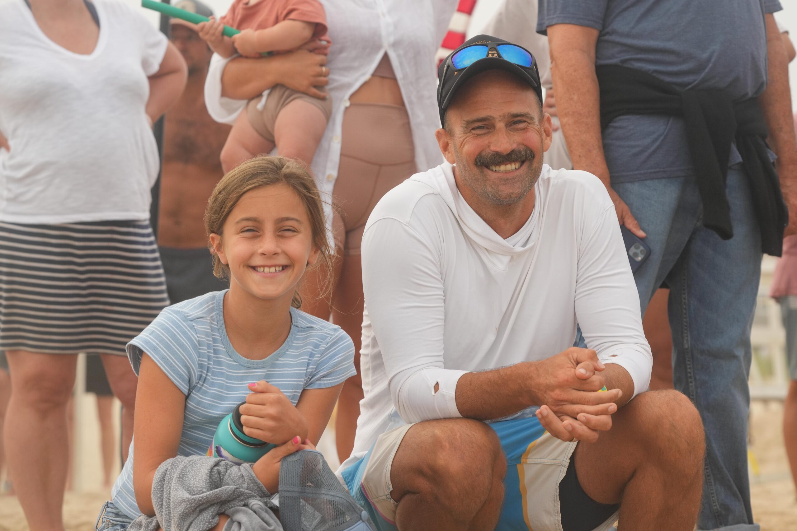 Dave Riley, a Southampton teacher and varsity boys soccer head coach who is a lifeguard himself, watches the Main Beach competition with his daughter Kendall.     RON ESPOSITO