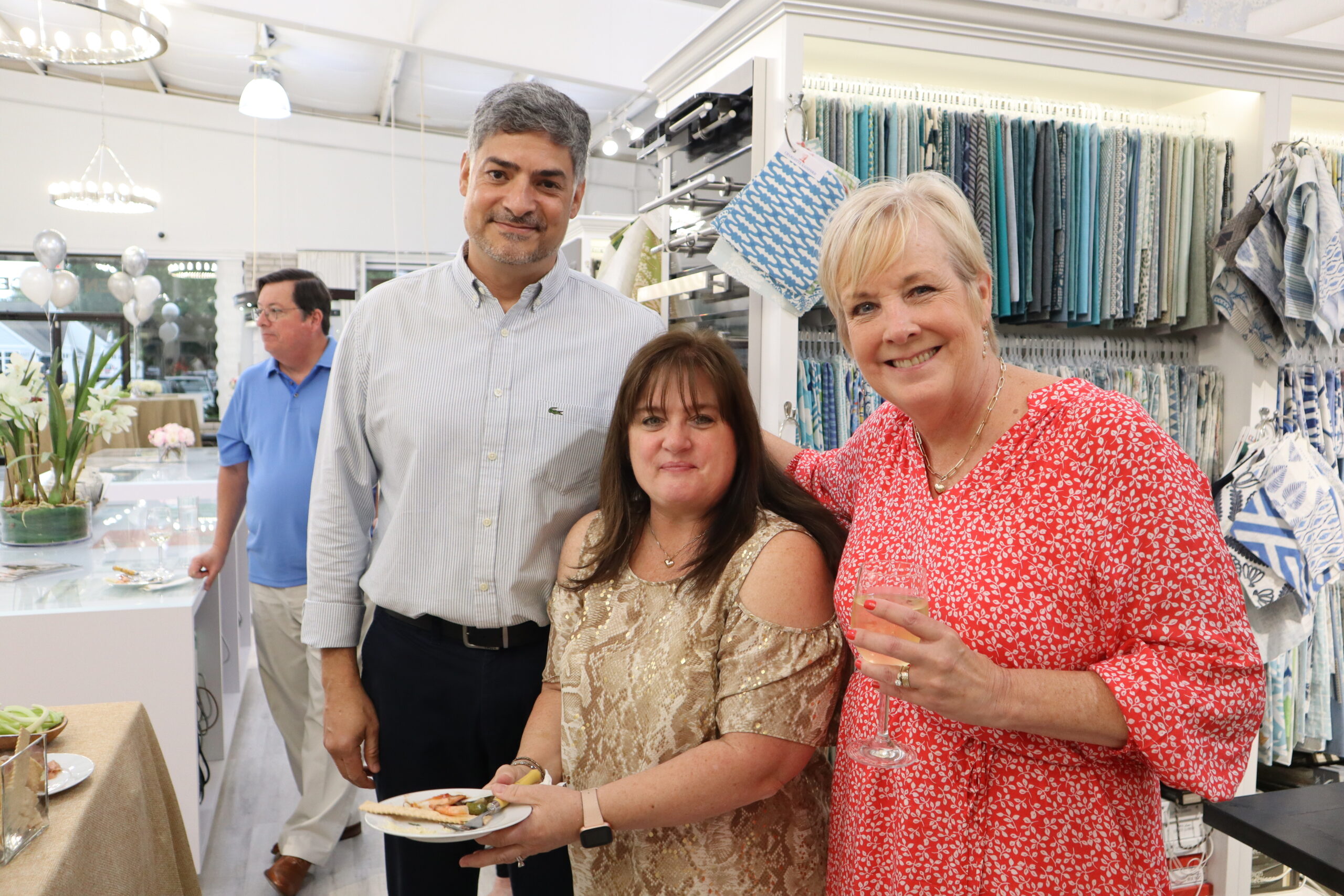 From left, Victor Pariz, a sales associate at The Carpetman, Corrine Kolb, the accounts receivable administrator at The Carpetman, and Ann Marie Pomposello, the administrative scheduler at The Carpetman, enjoy hors d’oeuvres and wine at the grand opening.  MEGAN NAFTALI