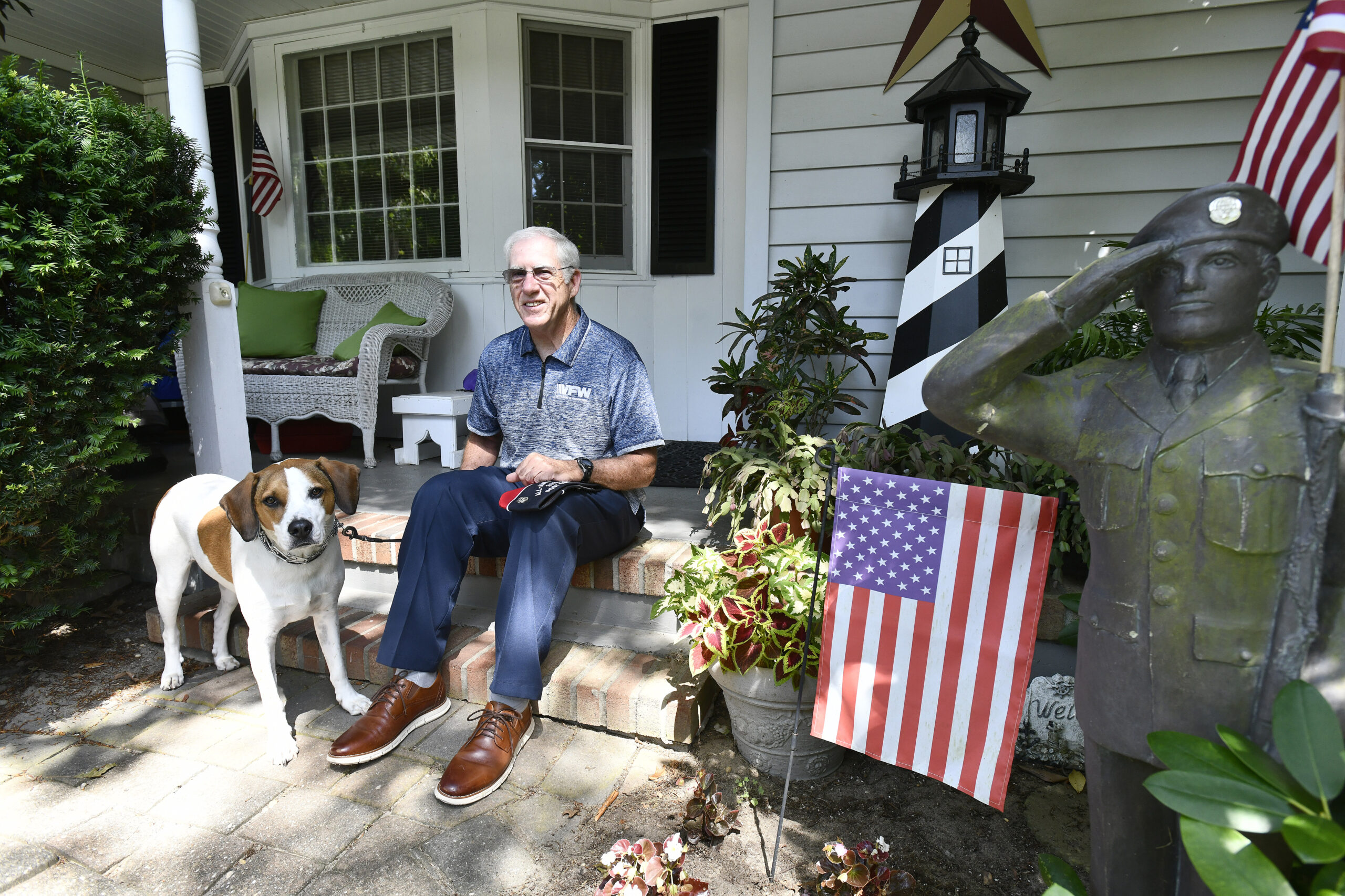 William Hughes and his dog, Buddy on the front parch of his Hampton Bays home.  DANA SHAW