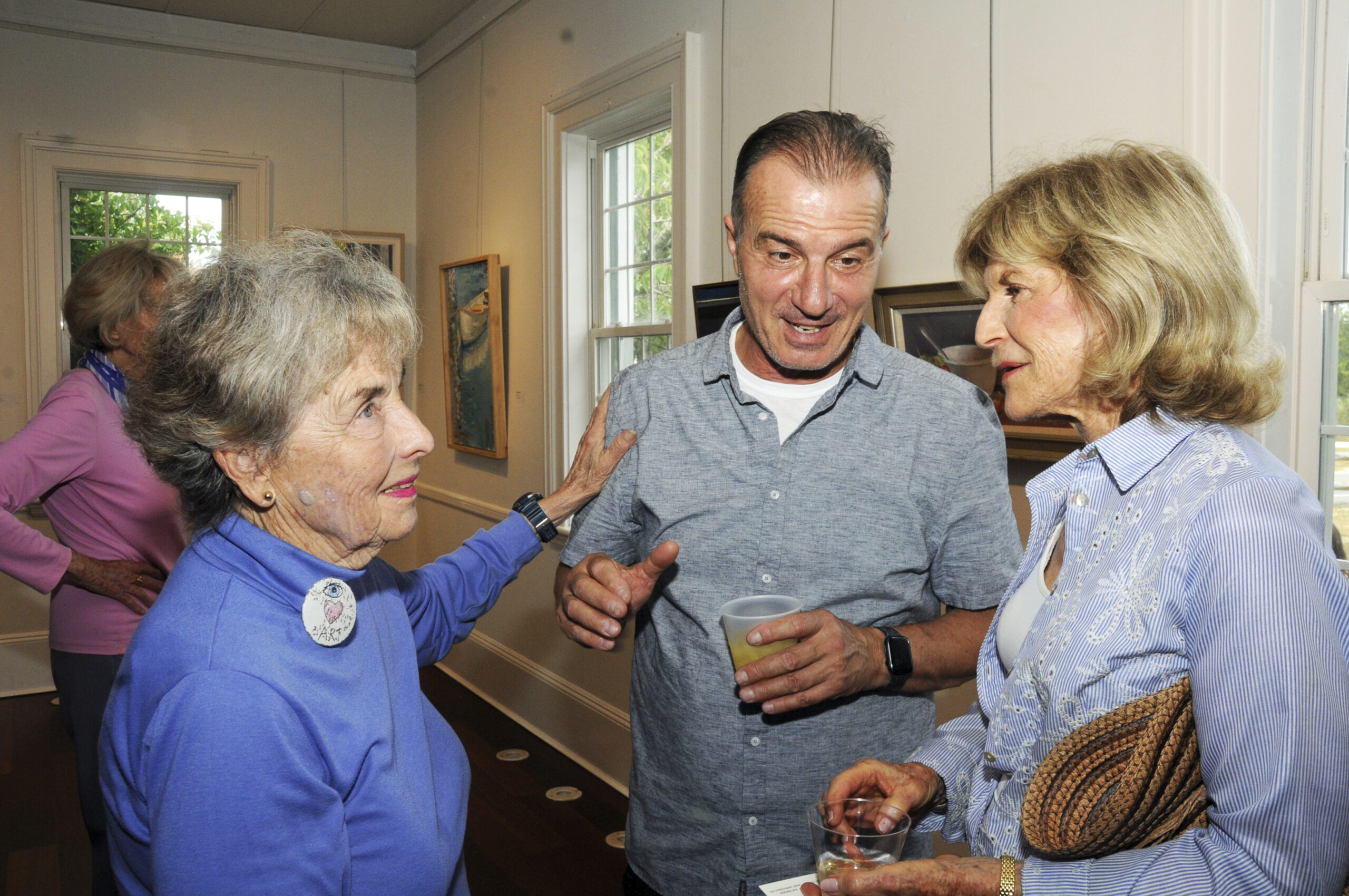 Anne Hecht, Haim Mizrahi and Betsy Pinover Schiff at the Springs Improvement Society's opening of its 55th Annual Springs Artists Invitational art show and sale at Ashawagh Hall. The show was curated by artist Haim Mizrahi, and featured a commemorative poster created and signed by Springs artist Eric Ernst.   RICHARD LEWIN