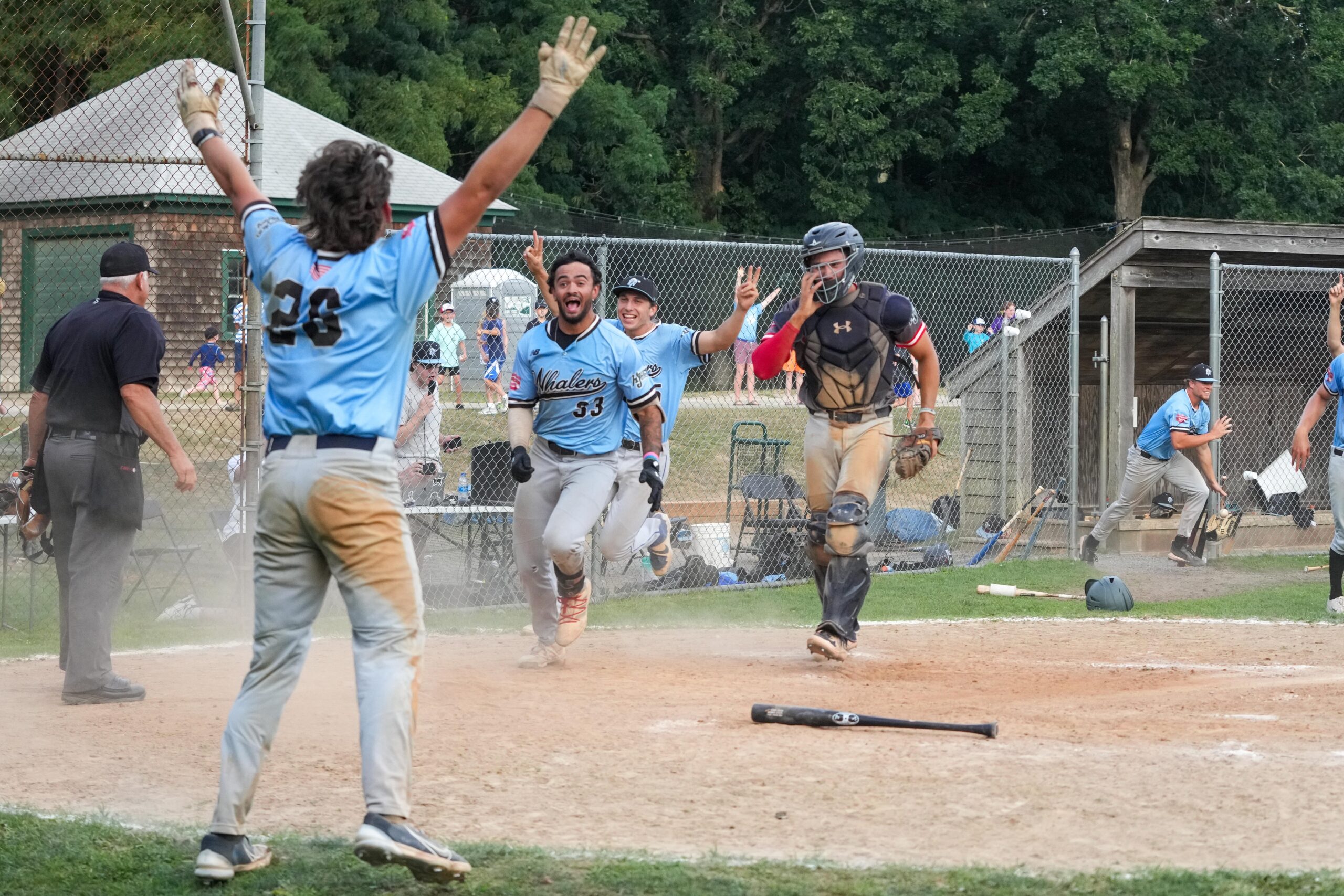 C.J. Dean leads the charge to meet D.J. Perron Jr. after he scored the game-winning run of Sunday's title-clinching victory.    RON ESPOSITO