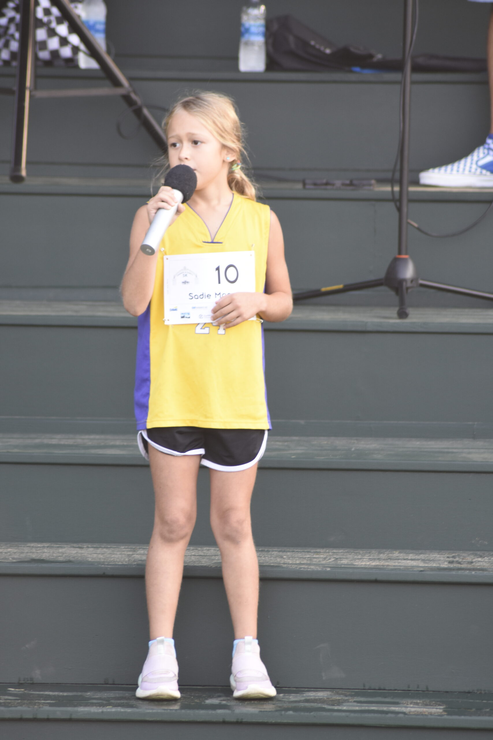 Sadie Finelli sang the national anthem on the steps of the newly renovated grandstands just prior to the second annual Mashashimuet Park Friends and Family 5K in Sag Harbor on Sunday morning.   DREW BUDD