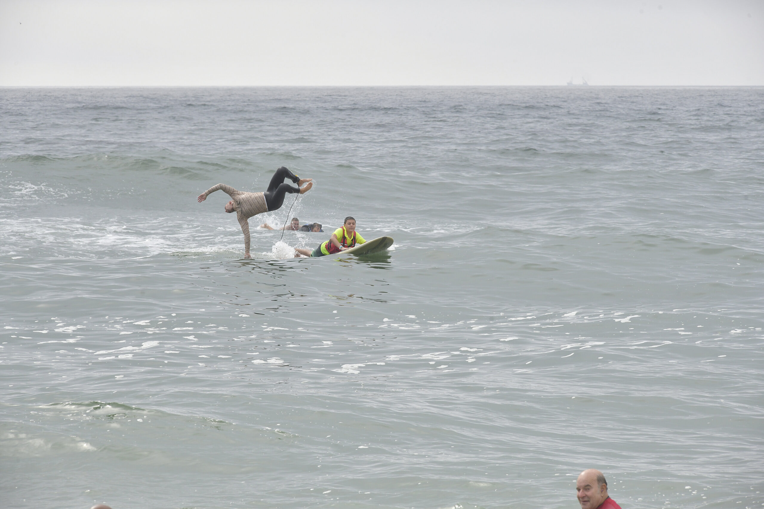 A surfer does a back flip off the board at Surfers for  Healing.   DANA SHAW