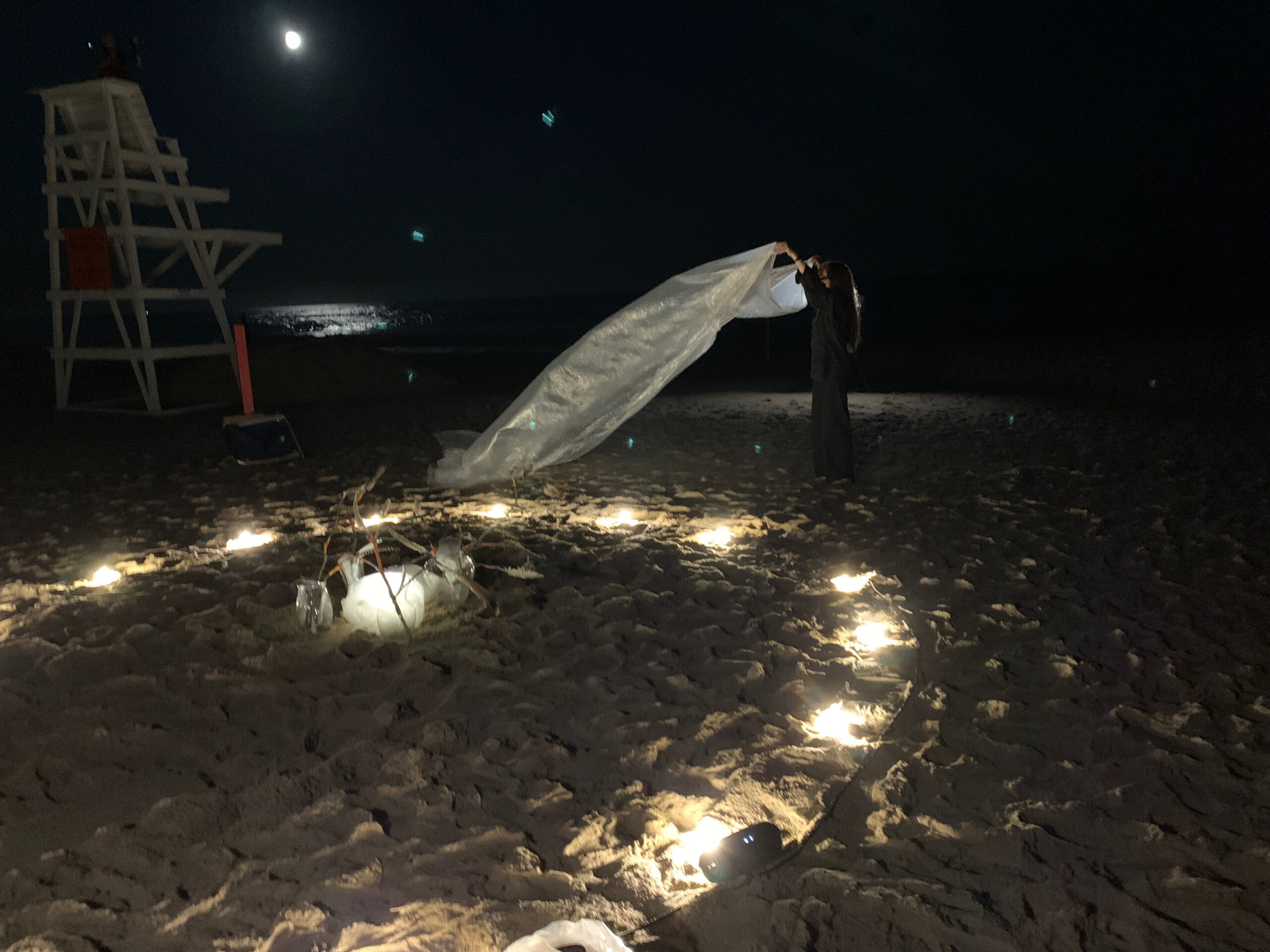 Artist Elana Bajo performing her art piece under the full moon at East Hampton's Main Beach on September 10 in response to a musical love letter from West Coast artist Jasmine Orpilla. ANNETTE HINKLE