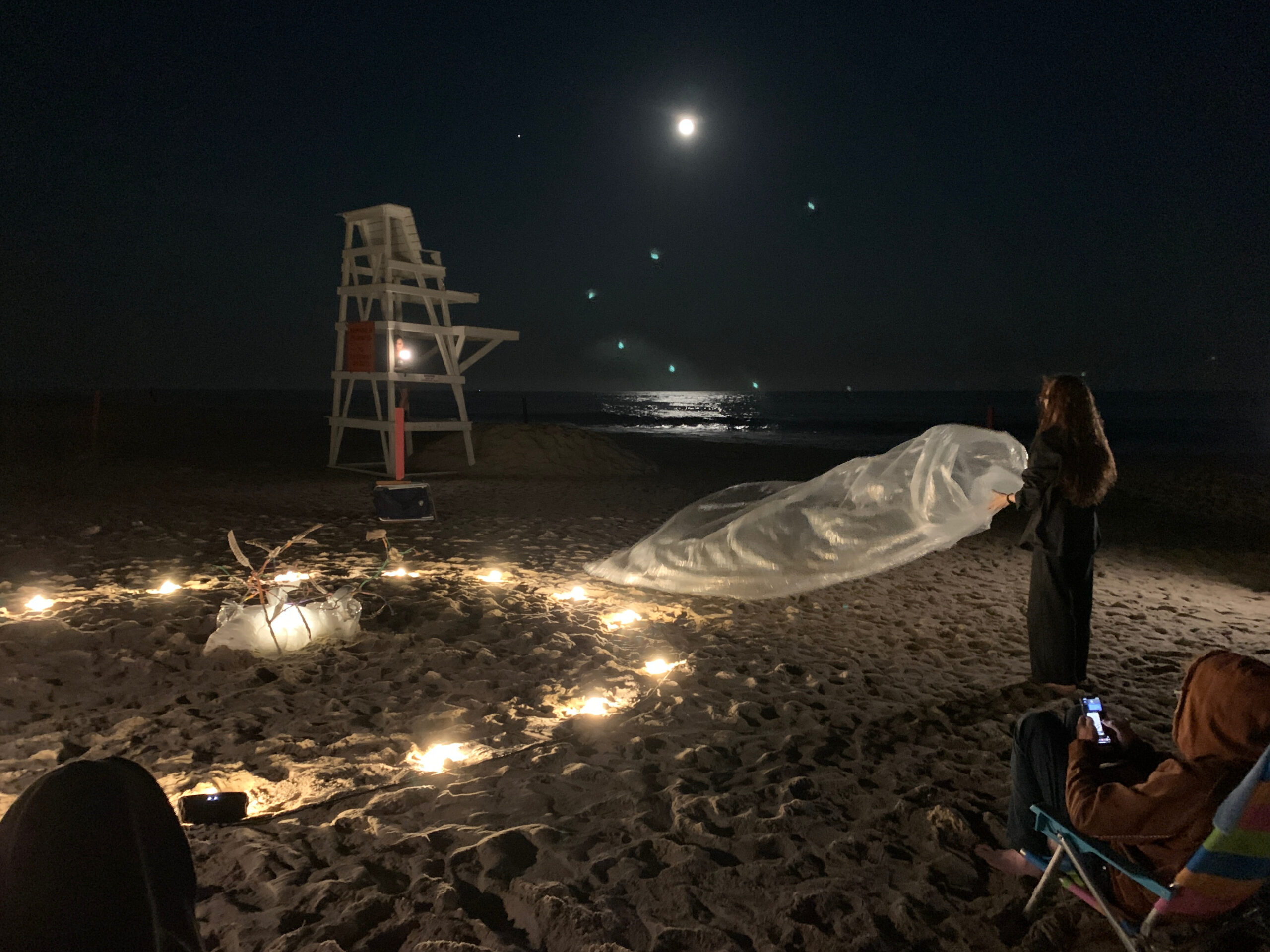 Artist Elana Bajo performing an art piece under the full moon at East Hampton's Main Beach on September 10 in response to a musical love letter from West Coast artist Jasmine Orpilla. ANNETTE HINKLE