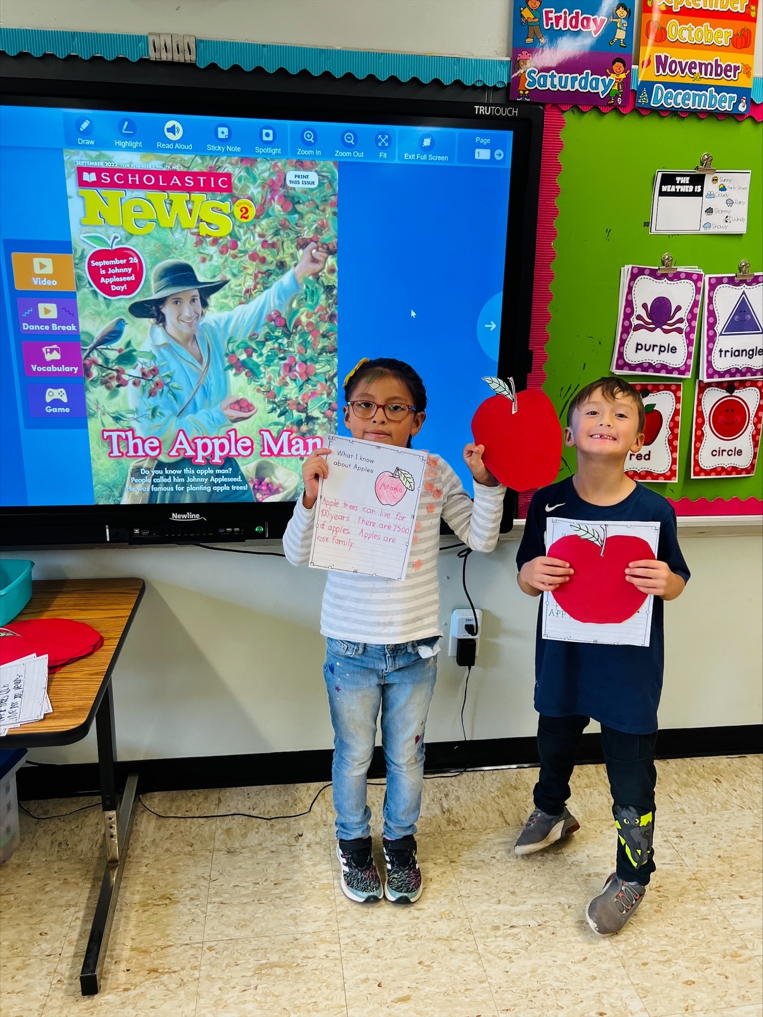 Hampton Bays Elementary School first-graders, including Aitana Quiguiri Guerrero and Juan Yara-Palacios, recently learned all about apples. The students read about Johnny Appleseed, researched and wrote about apples based on facts, and painted apple trees. COURTESY HAMPTON BAYS SCHOOL DISTRICT