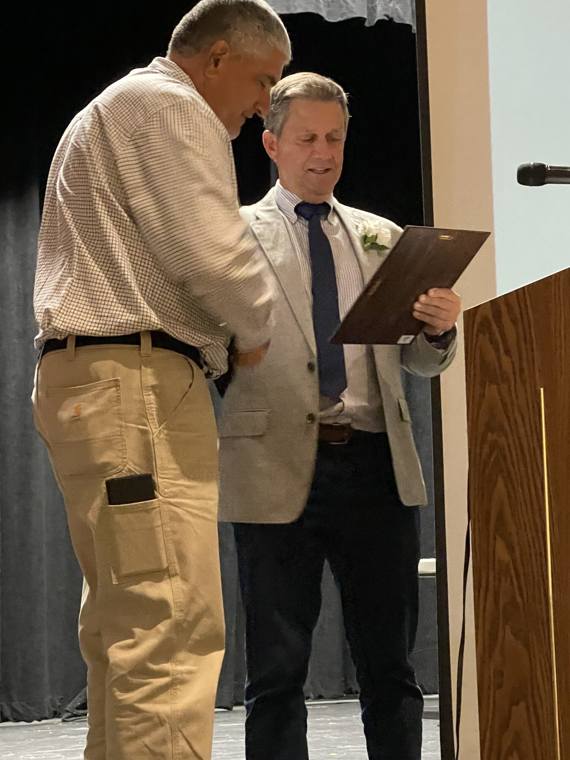 Jim Nicoletti hands over a plaque to Joe Vasile-Cozzo recognizing him for helping create East Hampton's Athletic Hall of Fame.    JIM STEWART