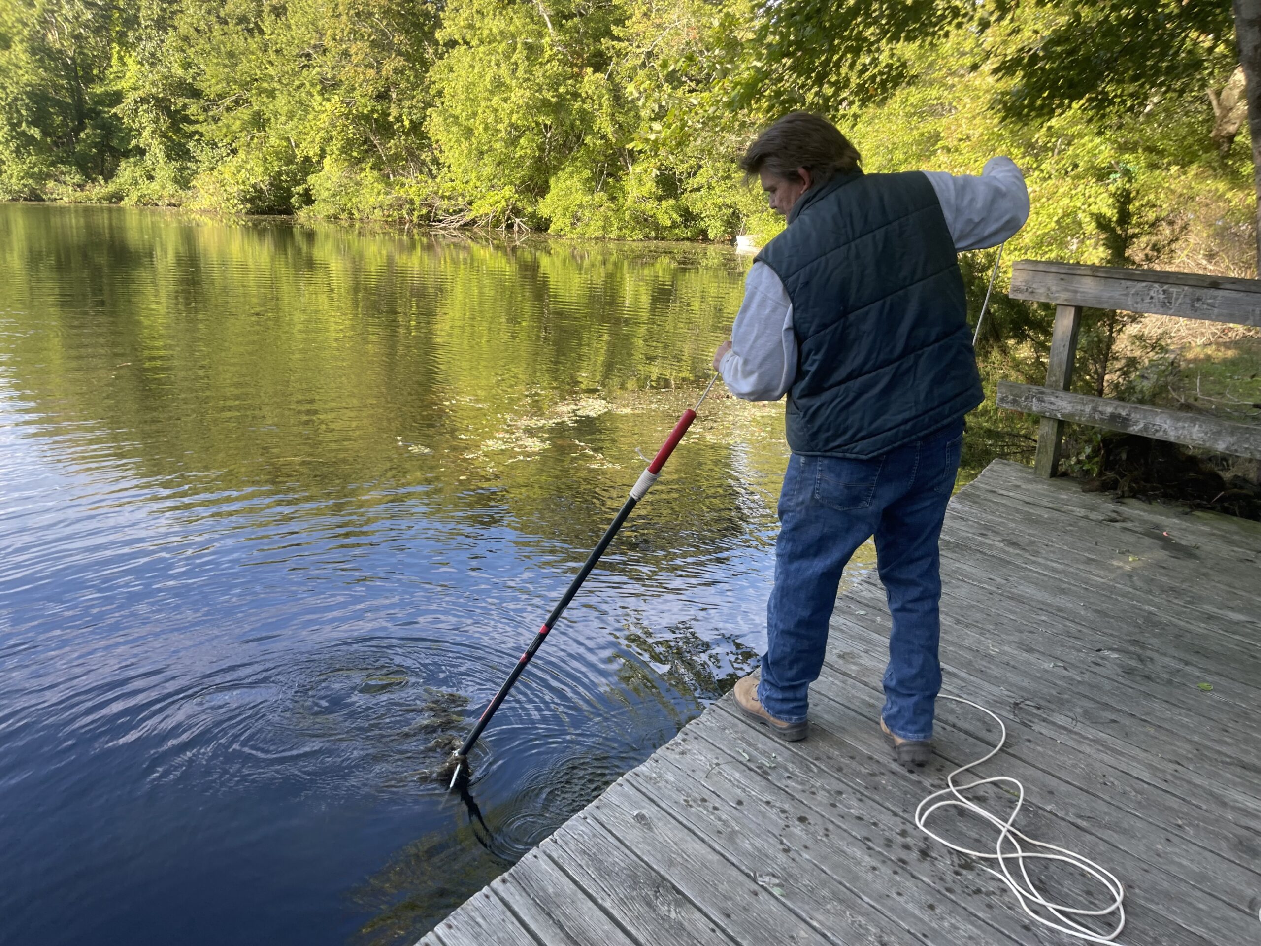Town Councilman Tommy John Schiavoni lent a hand during the cleanup of Trout Pond in Noyac on September 24.    DIANE HEWETT