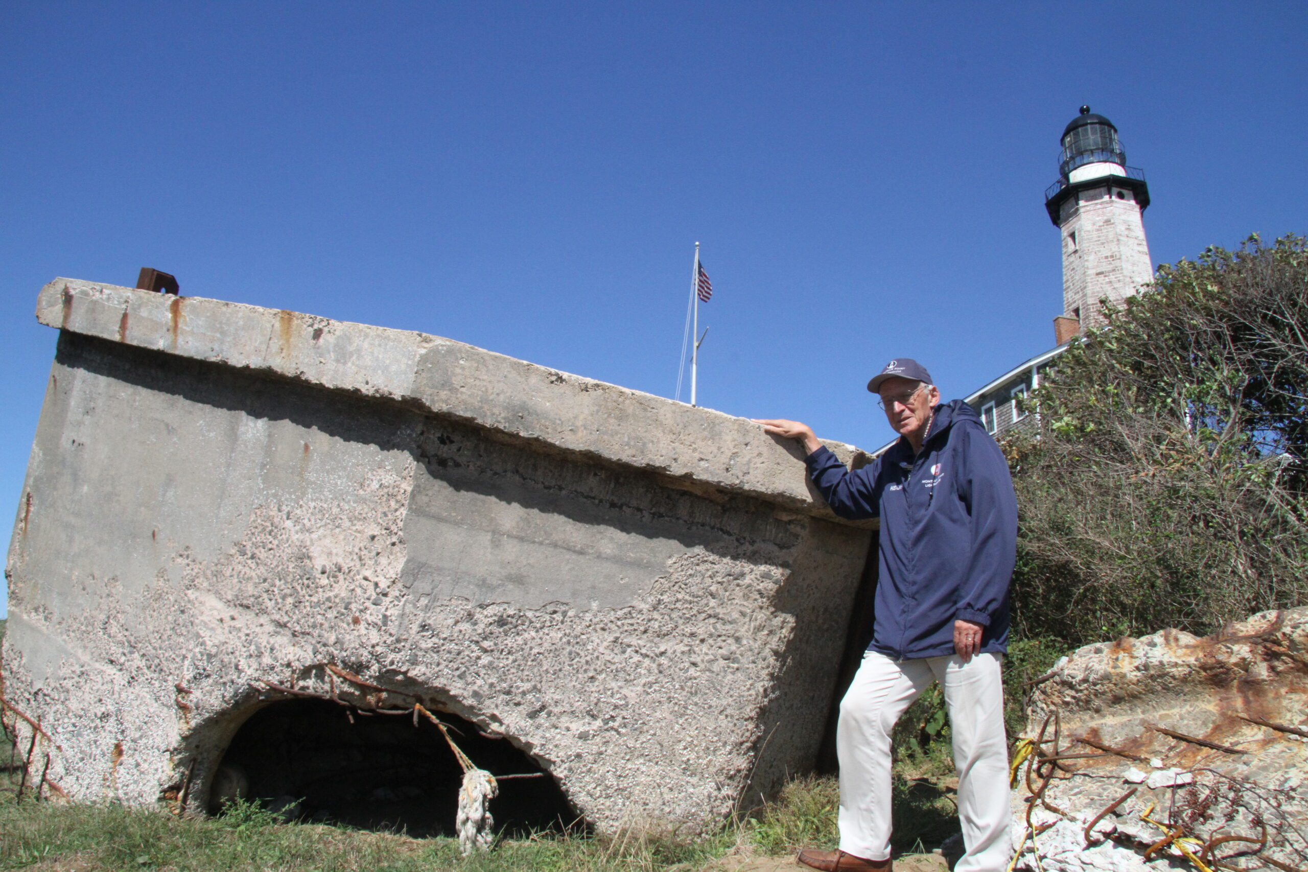 Henry Osmers, the Montauk Lighthouse historian, with the main hunk of the pillbox, which was lifted off the beach at the start of the current revetment extension, and will be reassembled and placed on the lighthouse property, where it had originally served as a WWII-era watch station.