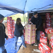 Marit Molin,  Heather Edwards and Chuck MacWhinnie distribute diapers on a rainy Saturday in the parking lot at the Unitarian Universalist Church in Bridgehampton.  DANA SHAW