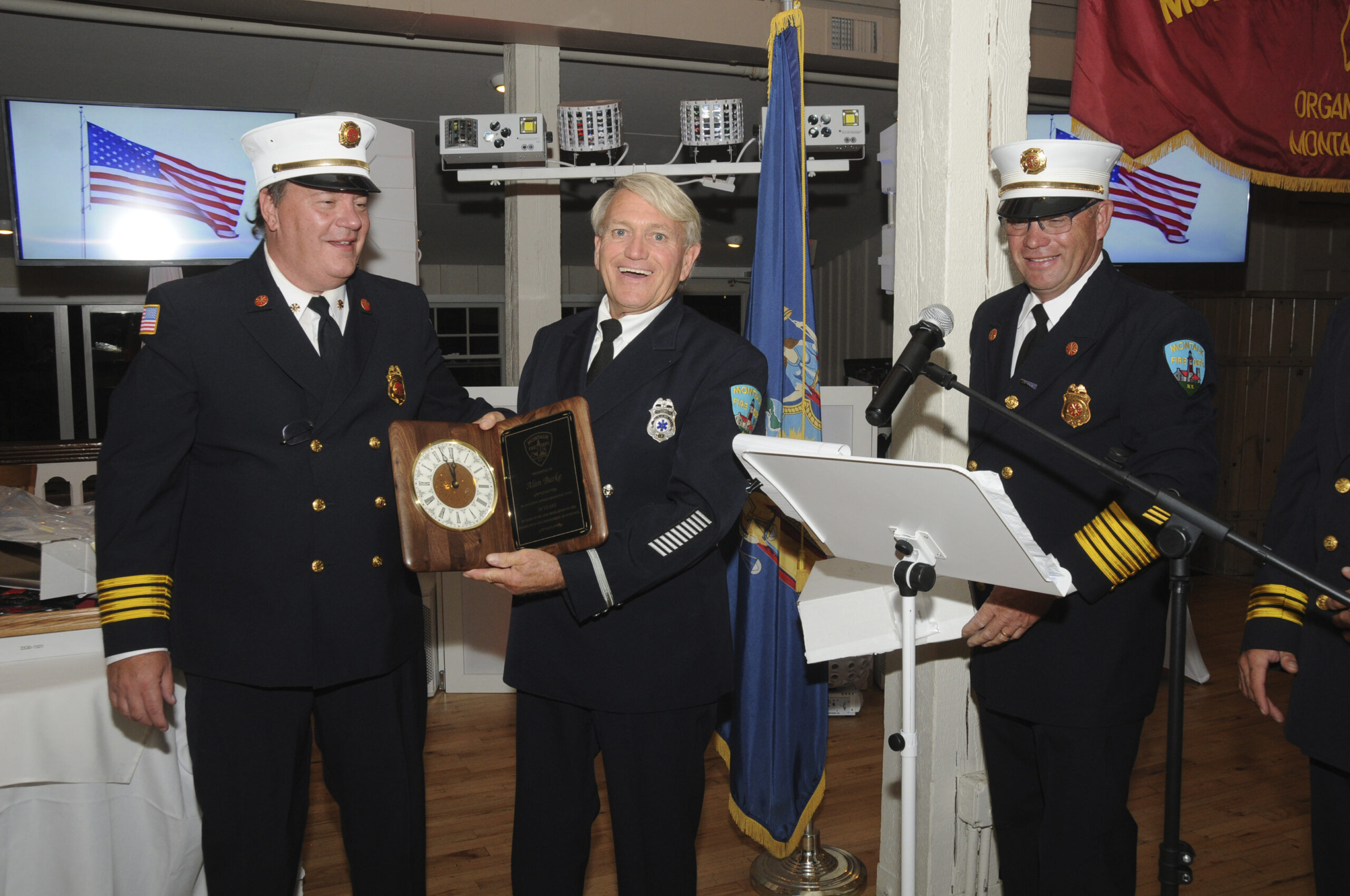 Alan Burke, center, received an award for his 50+ years of service to the Montauk Fire Department at the department's inspection dinner held on Friday evening at at Gosman's Restaurant.  RICHARD LEWIN