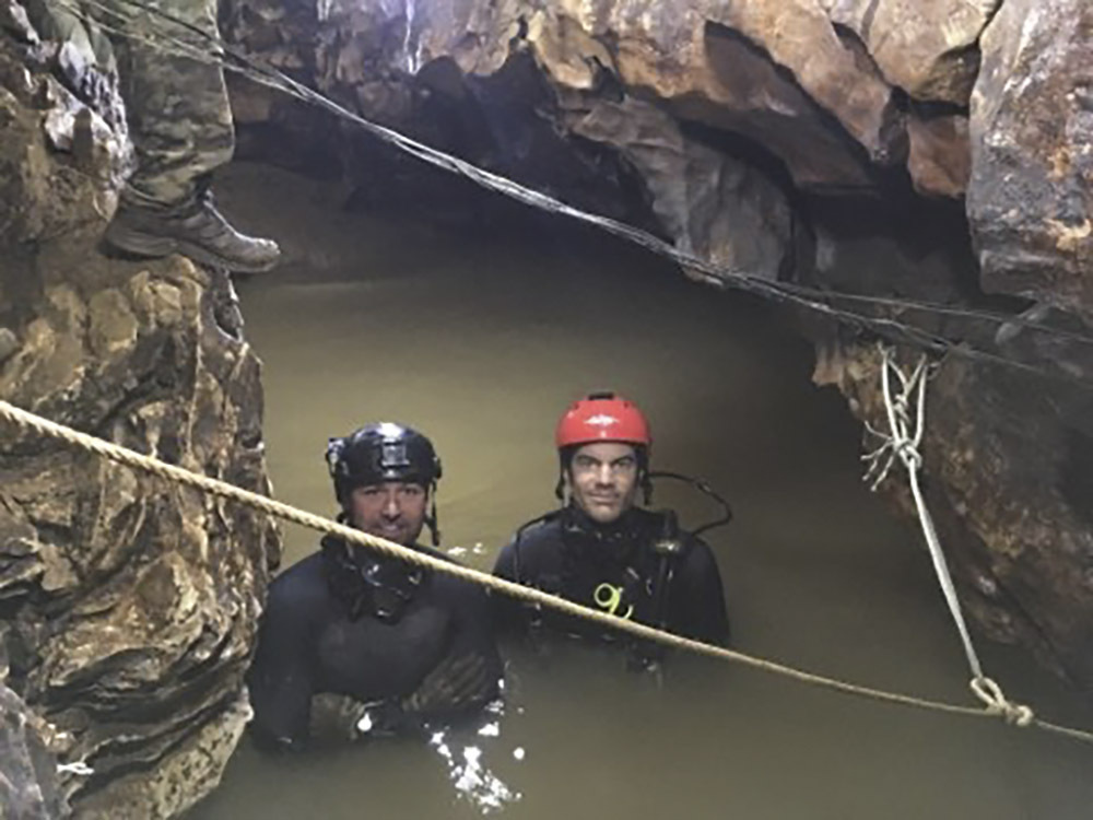 Tech. Sgt. Jamie Brisbin (with red helmet)  and Tech. Sgt. John Merchand in the cave in Thailand.  COURTESY ANG 106th Rescue Wing