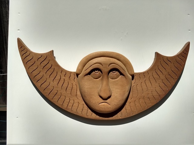An angel carving in wood by David Cosgrove, based on a carving from an 18th-century colonial cemetery gravestone.