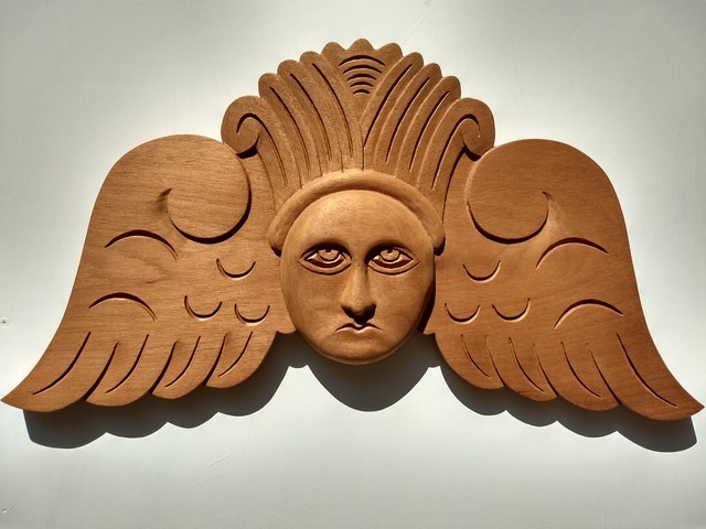 An angel carving in wood by David Cosgrove, based on a carving from an 18th-century colonial cemetery gravestone.
