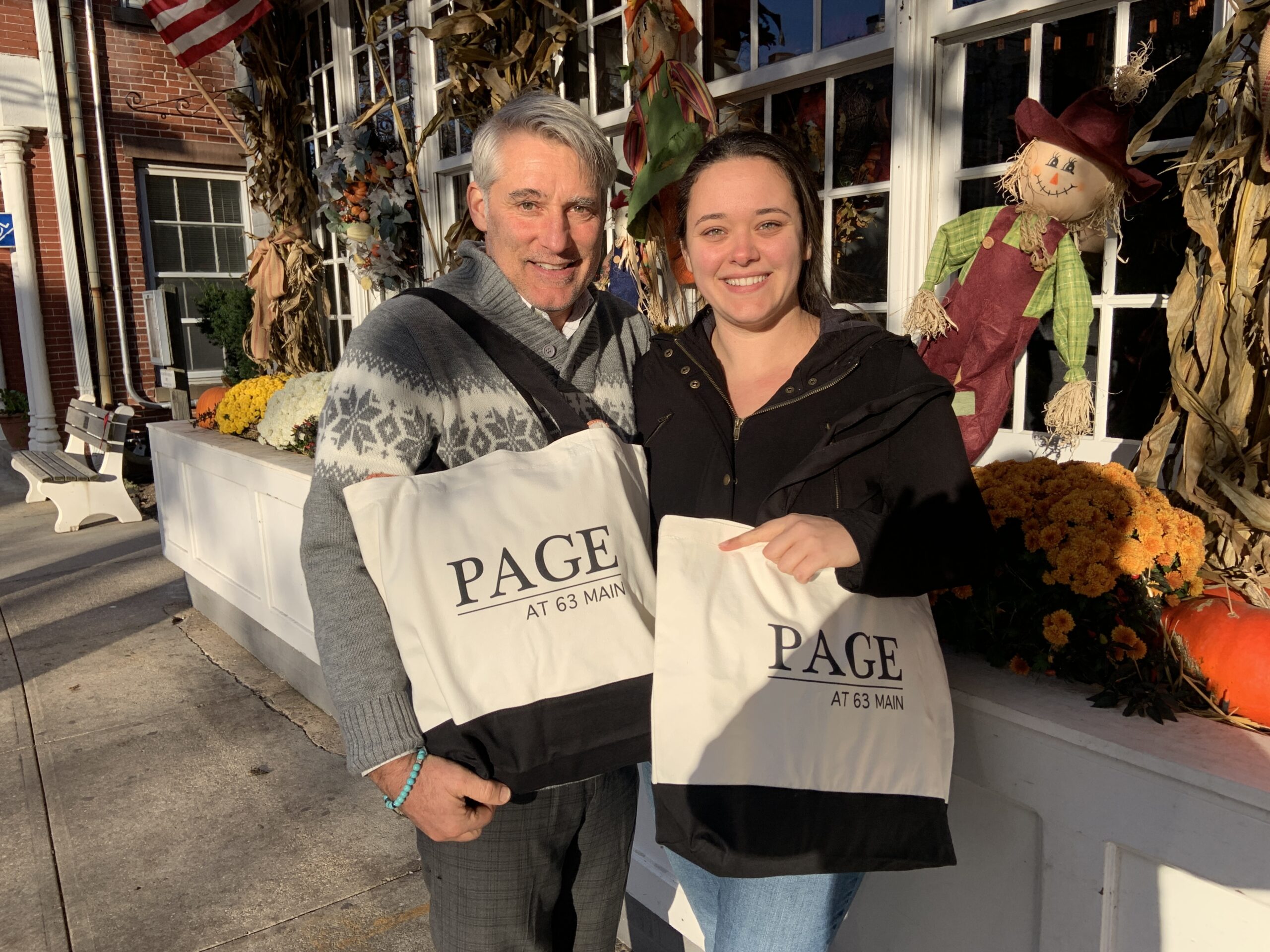 Eric Peele, the director of operations at Page at 63 Main, and Rae McMahon, the restaurant's director of marketing, with canvas tote bags that are being sold as part of a holiday fundraiser to benefit the Sag Harbor Food Pantry. STEPHEN J. KOTZ