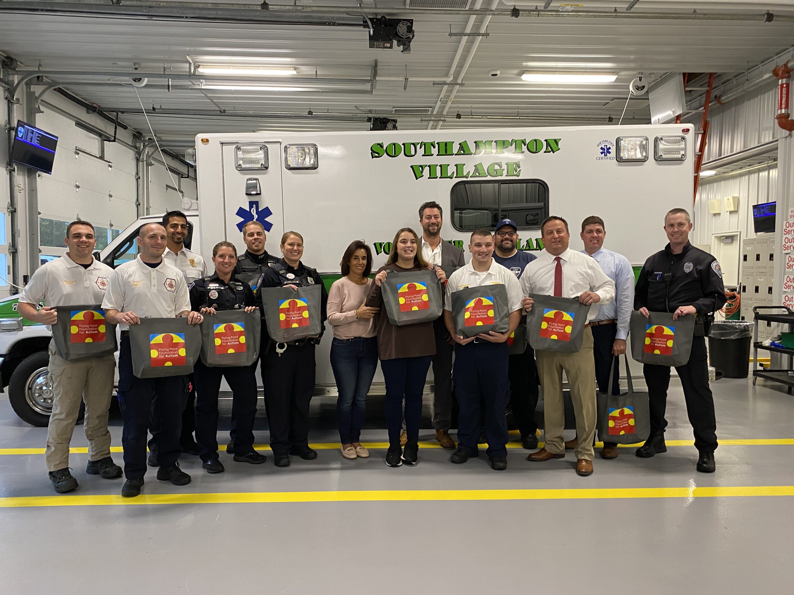Patty Tuzzolo, center, an executive board member of the Flying Point Foundation for Autism and her daughter Anna, who has autism, recently delivered FPF-GoBags to representatives of the Southampton Town Police Department, Southampton Village Police Department, Southampton Village EMS, Southampton Town EMS and Southampton Fire Department. COURTESY FLYING POINT FOUNDATION FOR AUTISM