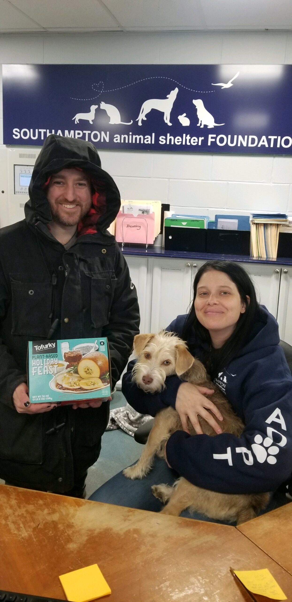 Humane LI president John DiLeonardo delivered tofurkey to Ally Burke, seen holding Jolene, of the Southampton Animal Shelter Foundation last week.    COURTESY HUMANE LI