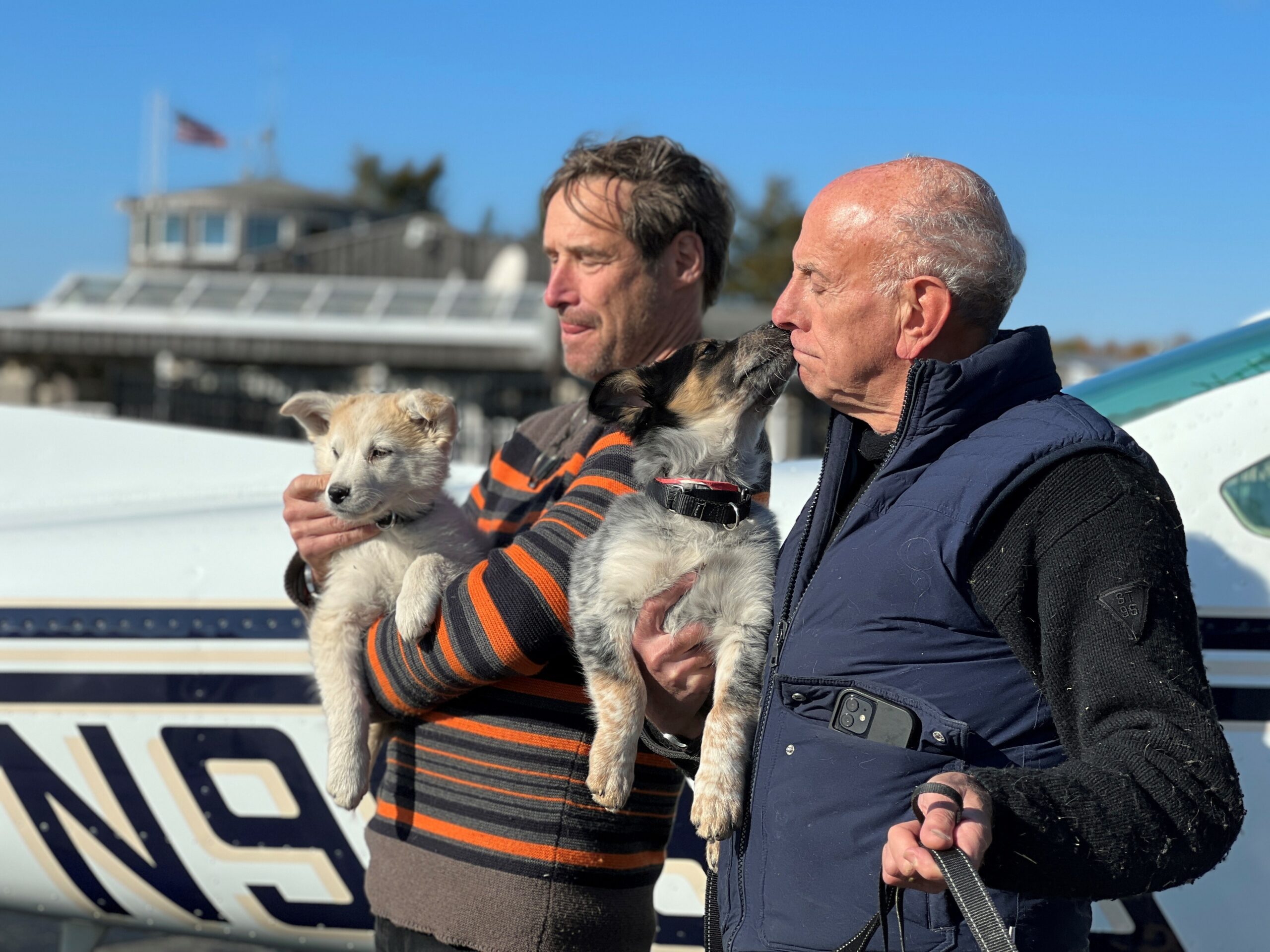 Pilot Dr. George Dempsey holds Biscochito and pilot David Reinbach holds Blue Corn after they arrived safely from New Mexico. COURTESY ANIMAL RESCUE FUND OF THE HAMPTONS