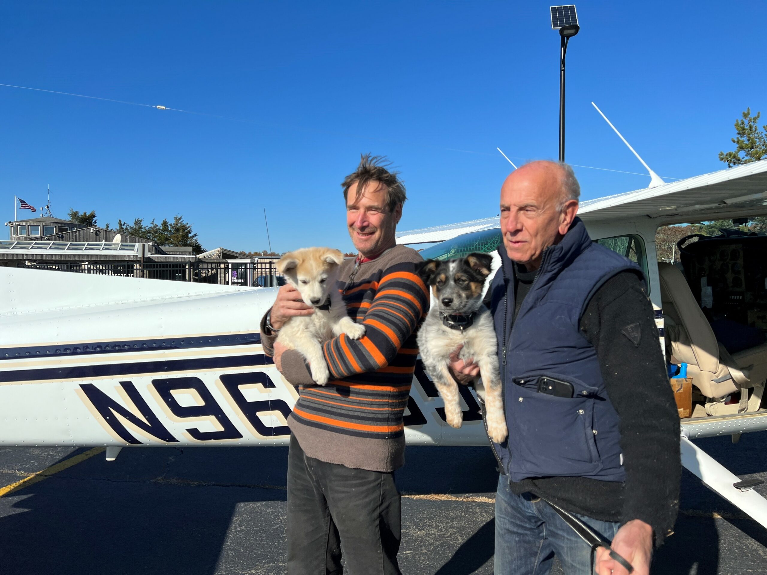 Pilot Dr. George Dempsey holds Biscochito and pilot David Reinbach with Blue Corn after they arrived safely from New Mexico. COURTESY ANIMAL RESCUE FUND OF THE HAMPTONS