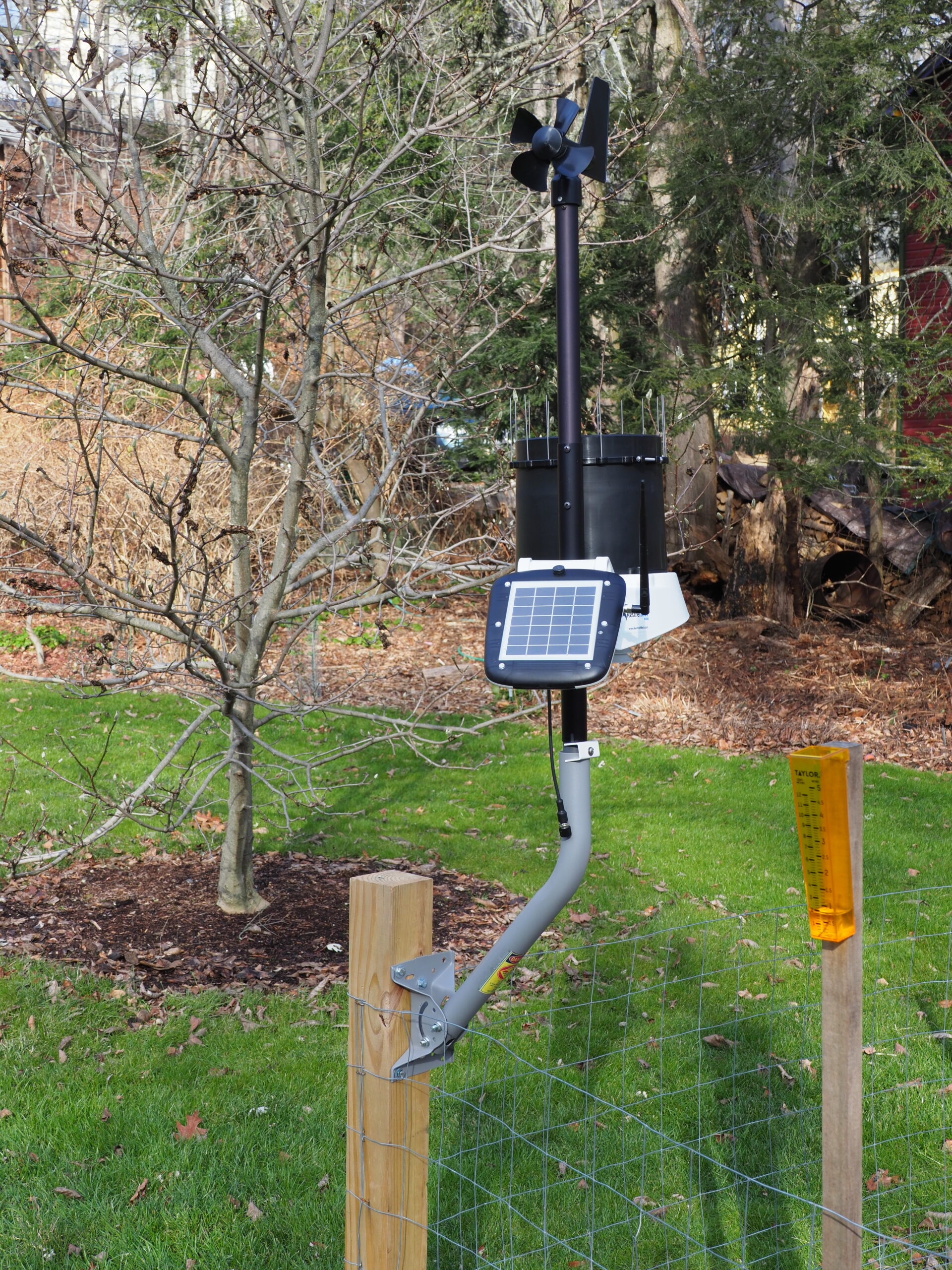 The Kestrel 6000 (WS 6000) from Ambient Weather. This is the largest of the four units tested and it’s mounted on a steel mast attached to a 4x4 pressure treated post sunk 3 feet into the ground.  On top is the propeller-type anemometer/wind vane. Below that is the rain collector (with spikes to keep birds out). In the front (facing) is the solar panel with the cell antenna on the right of the solar panel. This came in a large box and was easy to assemble and set up. To the right is the plastic 