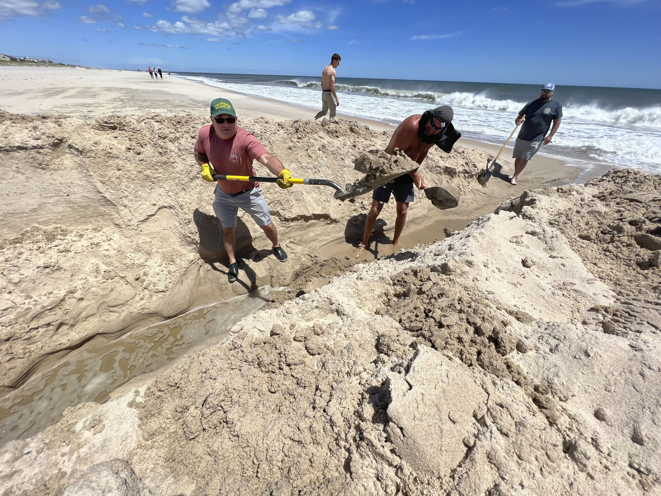Last summer volunteers attempted to hand-dig the cut from Mecox Bay to the ocean. This week heavy machines are at work in the dynamic system.    DANA SHAW