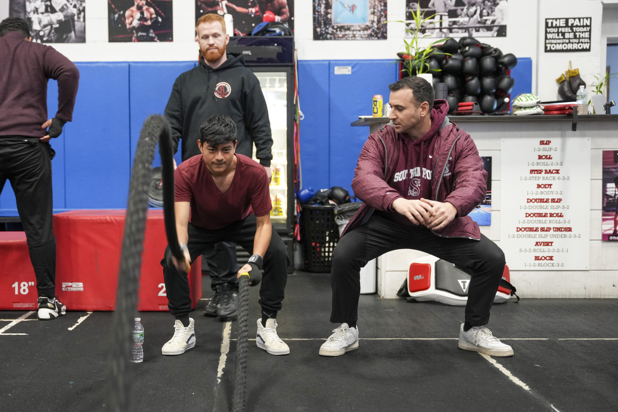 Avery Crocker, left, and Christopher DeRosa make sure student Jorge Cuautle Campohermoso is using proper technique working out with ropes.  RON ESPOSITO