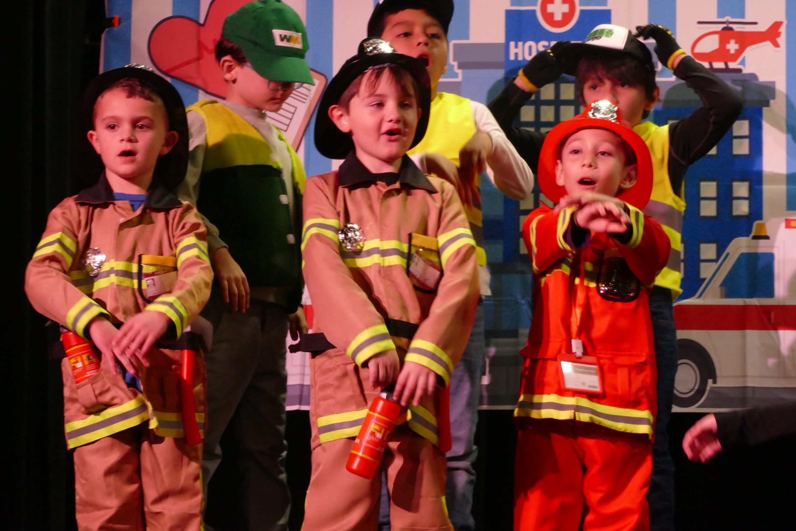 Our Lady of the Hamptons School first-graders, from left, Dillon Reese, Joseph Kampf and Leonardo Mellado, dressed as firefighters sing for the community.  COURTESY OUR LADY OF THE HAMPTONS