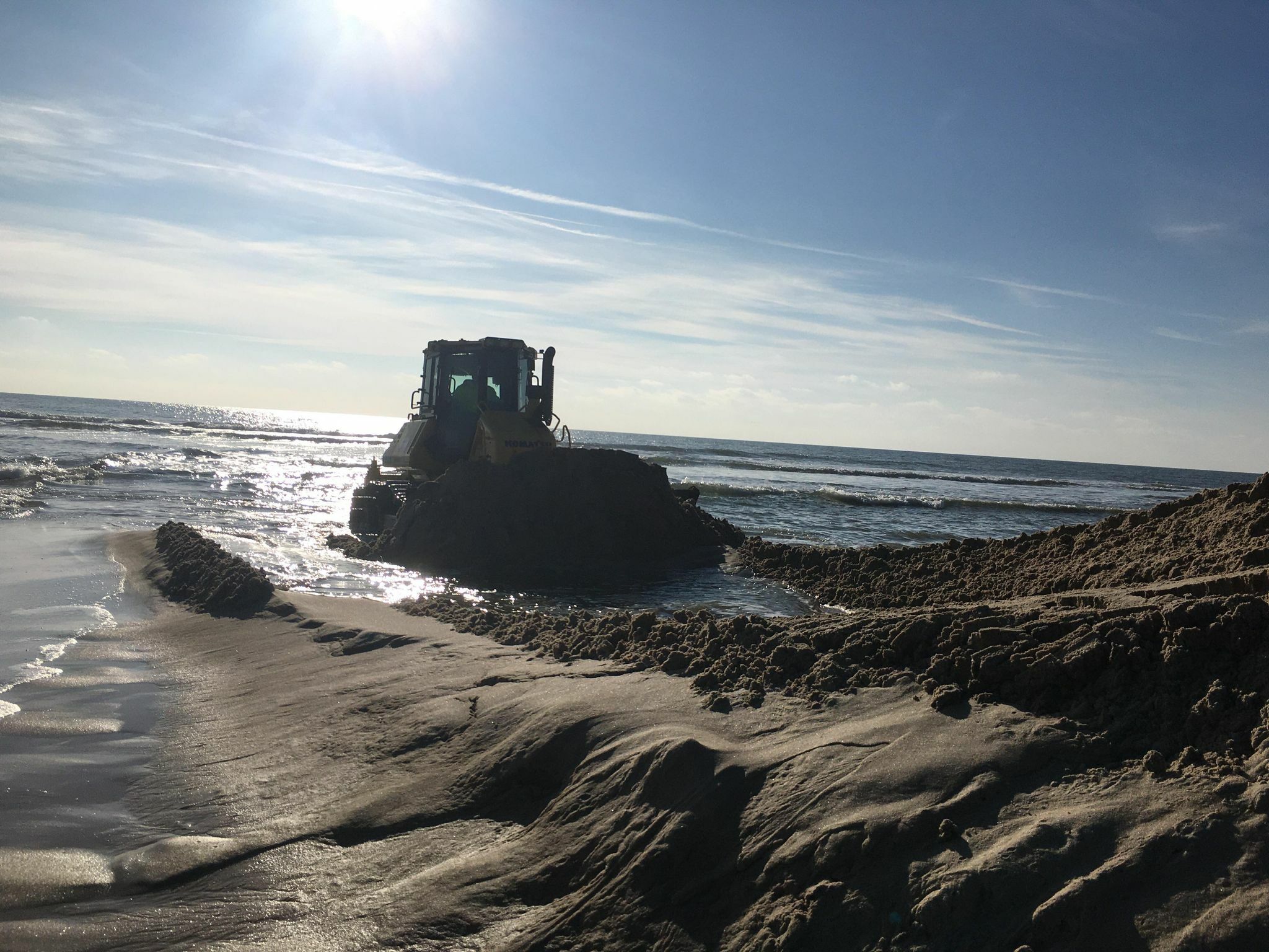 Out in the surf, the bulldozer crafts the sand mountain at the Mecox cut.    KITTY MERRILL