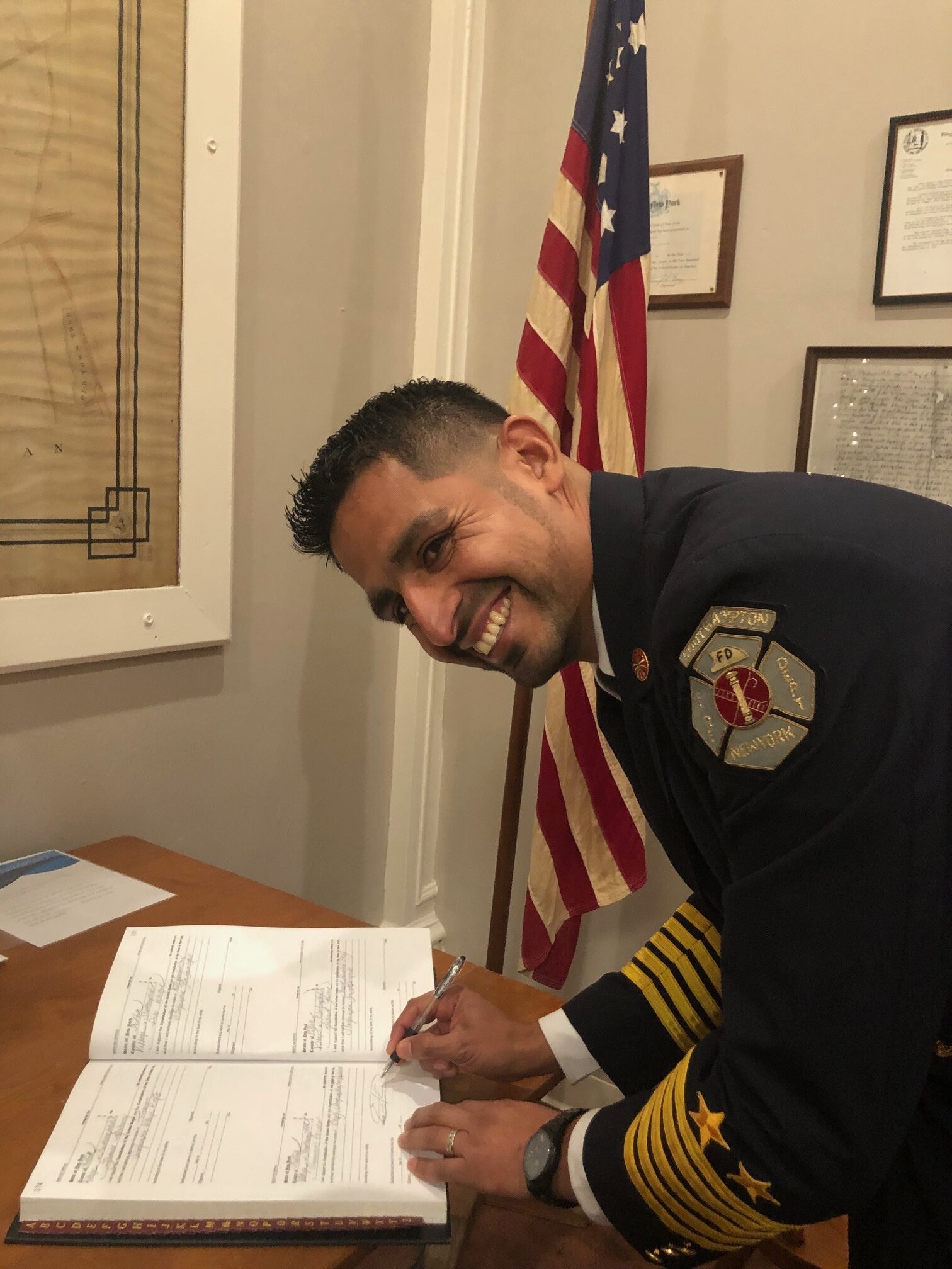 Southampton Village Fire Department's new chief, Emanual Escobar signs the official record after his swearing in.   CAILIN RILEY