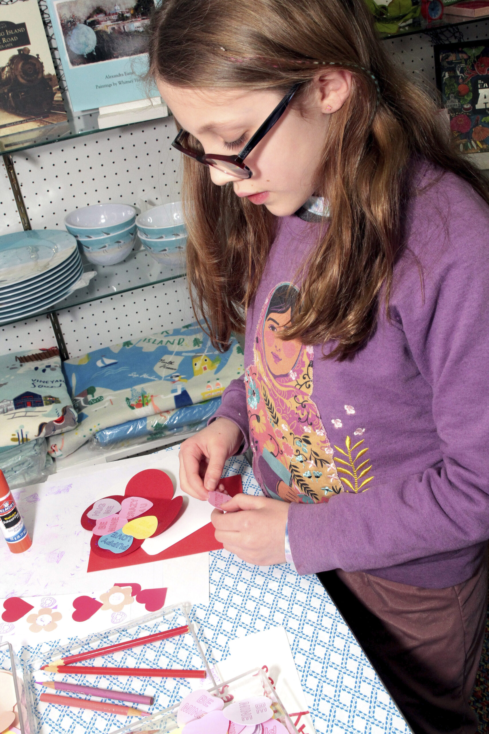 Hannah Unander works on a Valentine's card at the Wharf Shop on Saturday.  TOM KOCHIE